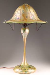 Phoenix Studios John Cook Millefiori Glass Lamp: Phoenix Studios John Cook art glass table lamp. Features iridescent green circular flared shade and body with a green, blue and brown millefiori pattern on a closed base. Etched mark John Cook