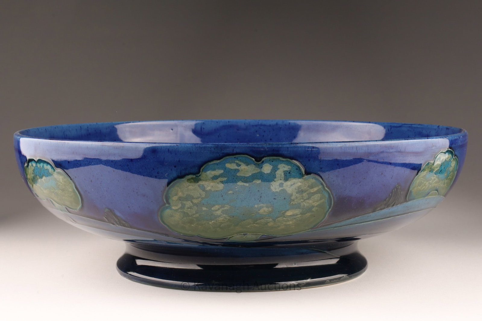 William Moorcroft Moonlit Blue Footed Bowl: An antique William Moorcroft Moonlit Blue footed bowl, dating back to the 1920s from the collection launched in 1922. It features a deep blue background with stylized trees in light blue and green. Im