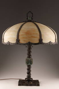 Art Nouveau Style Slag Glass Table Lamp: Art Nouveau or Arts and Crafts Style Slag Glass Table Lamp. With a twisted base and lion masks, acorn lamp pulls and 8 panels of caramel-coloured swirling slag glass. 27 inches H x 20 W.