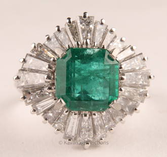 Vintage Platinum Diamond and Emerald Ring: A vintage platinum ballerina-style cocktail ring featuring numerous tapered baguette cut diamonds surrounding an exceptional central octagonal-cut emerald weighing 2.09 carats of Vivid Green color. Th