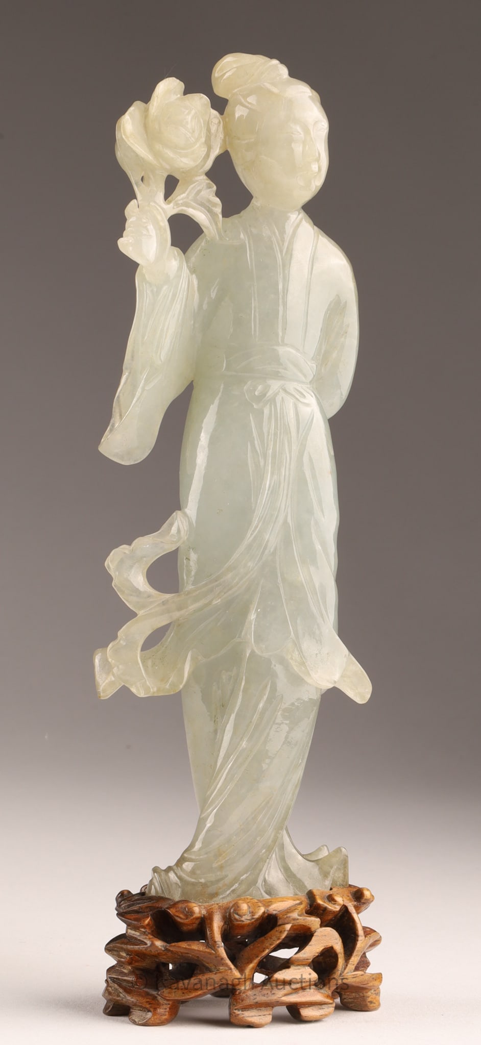 Chinese Finely Carved Jade Female Figure Guanyin: Chinese Finely Carved Jade Sculpture of a Female Figure or Guanyin holding a flower, mounted on to shaped wood base, measuring 7 inches H including stand, figure measures 6 inches H x 2 W.