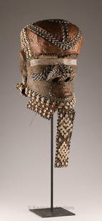 African Kuba Bwoom Helmet Mask Congo DRC: Kuba Bwoom helmet mask from the Democratic Republic of Congo crafted from wood and copper, adorned with various materials such as textiles, cowrie shells (cauri), glass beads, and raffia. Bwoom masks