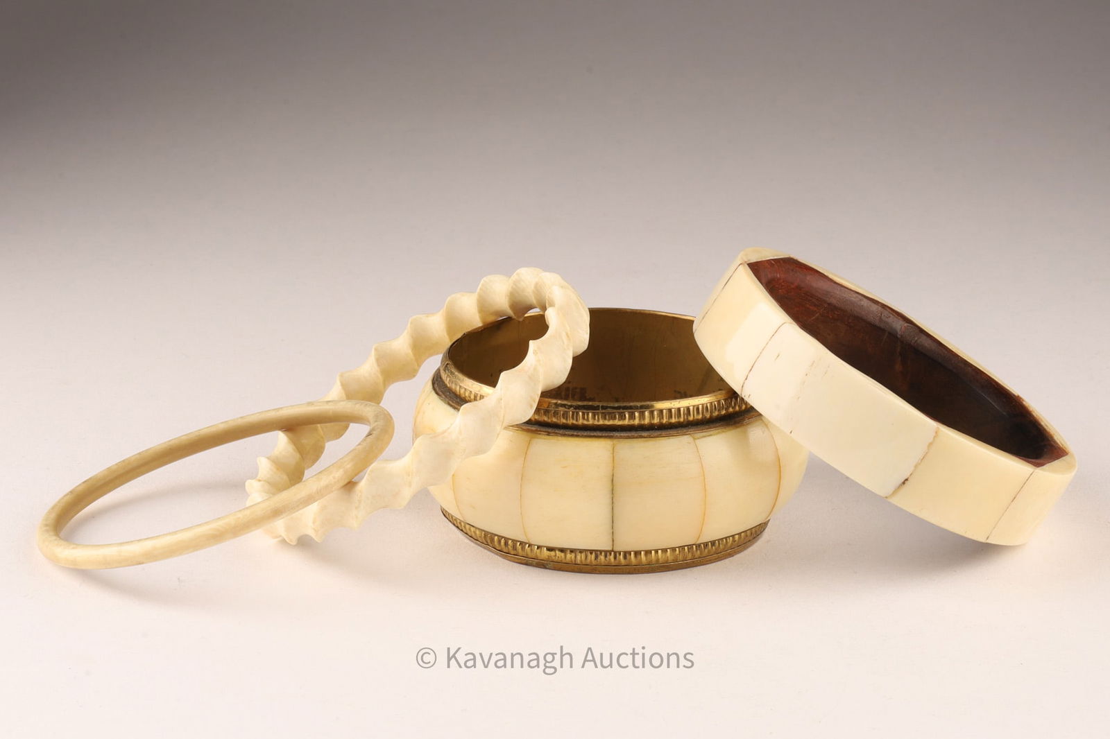 Lot of 4 Carved Bone Bangles: Lot of 4 Carved Bone, Brass and Wood Bangles. THIS ITEM CANNOT BE EXPORTED FROM CANADATwisted bangle measures 9 inches circumference