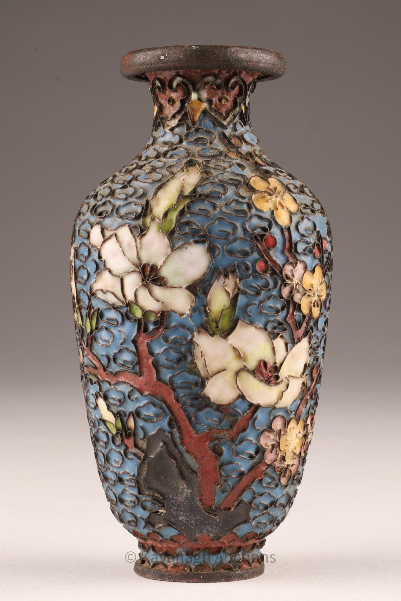 Antique Chinese Cloisonne Miniature Vase: A finely crafted small cloisonne vase, dating to the late 19th or early 20th century, featuring a raised enamel floral design of magnolia and cherry blossoms in soft pastel tones against a rich blue g