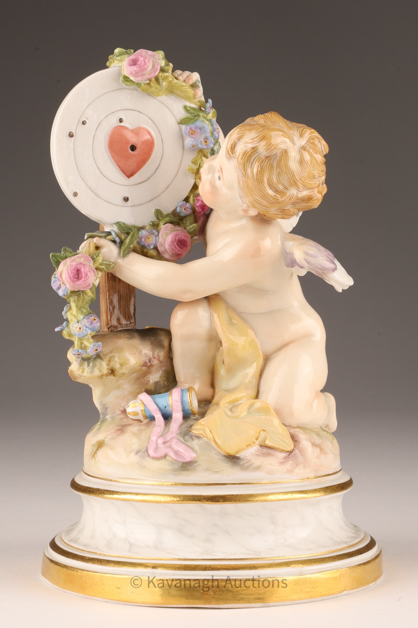 Meissen Porcelain Figure Of Cupid Garlanding a Heart Target: Meissen Porcelain Figure Of Cupid garlanding a heart target, incised number L123 with blue Meissen mark under glaze, 6.5 inches H x 3.5 W, 16cm. Small chip to top of garland. 