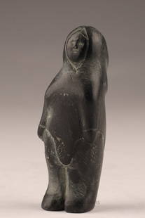 Small Inuit Stone Carving of Standing Woman: A hand-carved Inuit stone figure of a standing woman in traditional hooded parka. The carving, in dark stone with natural surface inclusions, features a stylized face and simplified form, typical of