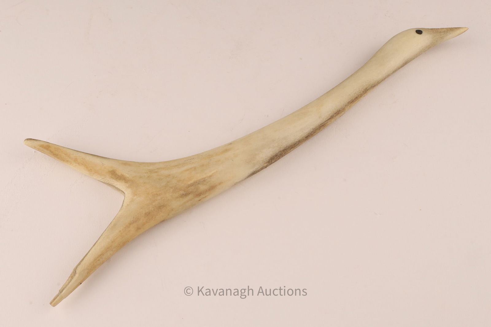 Inuit Carved Bone Sculpture of a Bird: An Inuit carved bone sculpture, cleverly worked from a naturally branching piece to depict a long-necked bird in flight or poised stance. Measuring approx. 10 inches across, the carver has taken advan