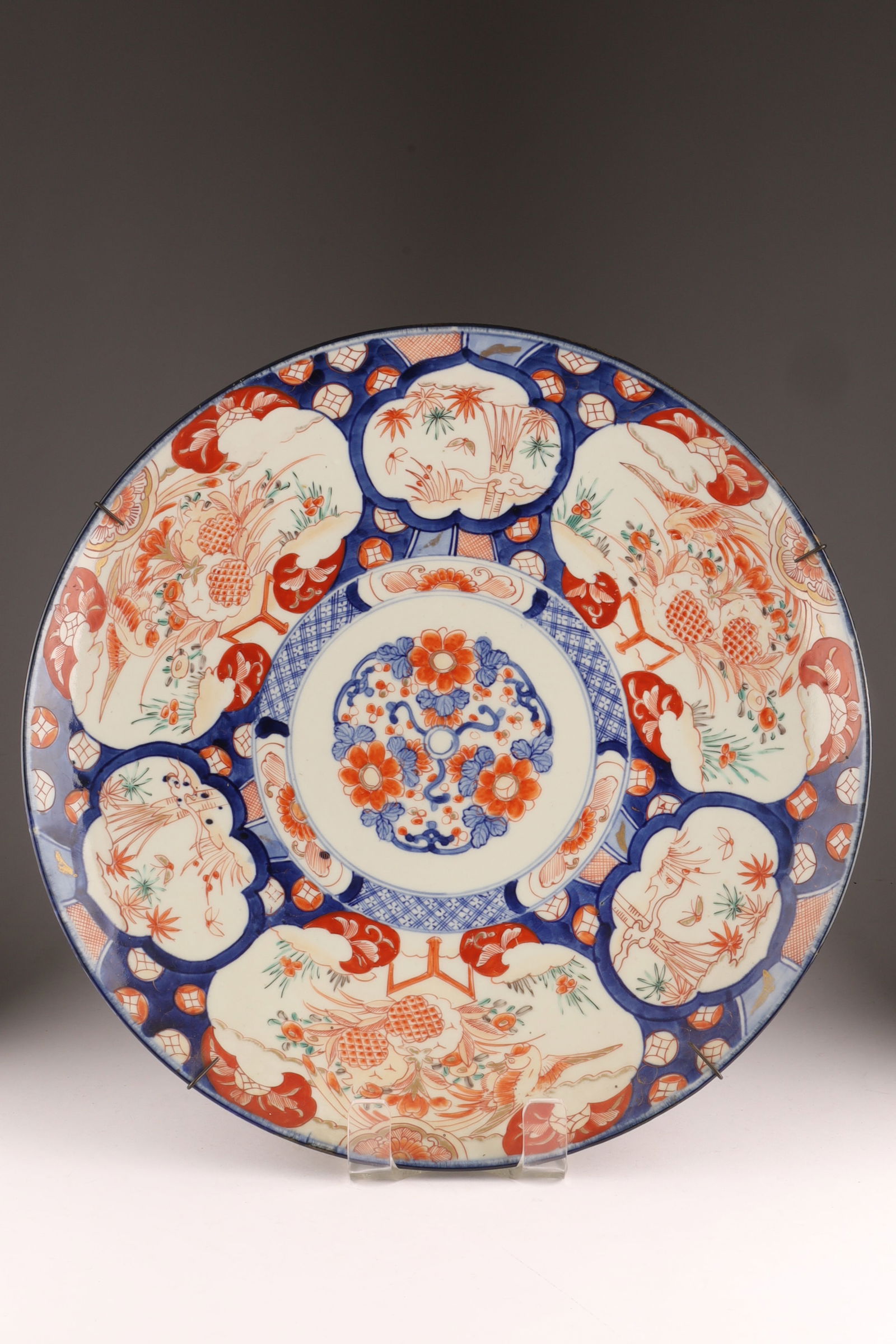Large Japanese Imari Charger: Large Japanese Imari Charger decorated in blue and red with a wire plate hanger. 18 inches diameter.