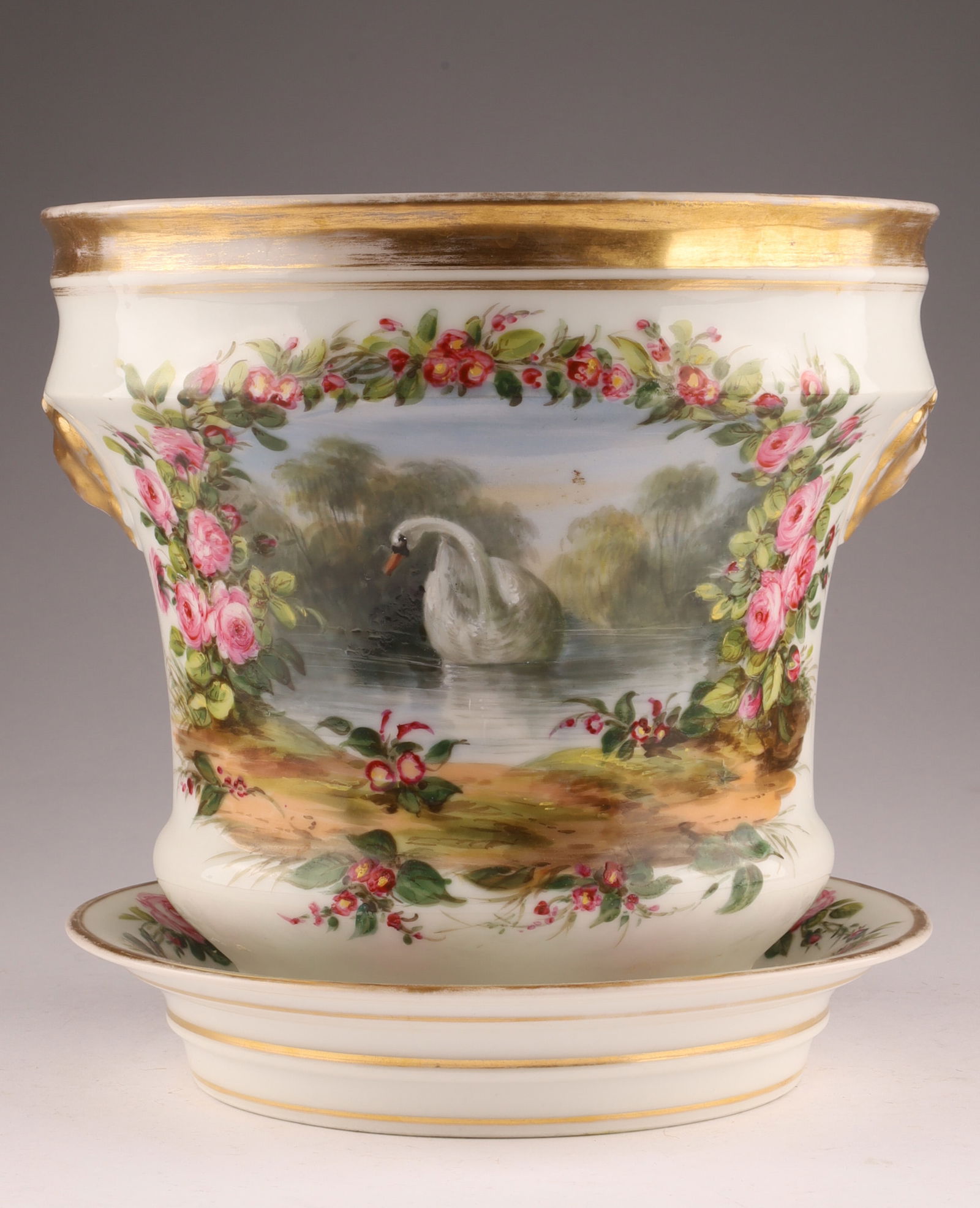 Hand-Painted Porcelain Cachepot with Saucer, Continental, 19th Century: Porcelain cachepot finely hand-painted with a landscape cartouche framed by garlands of pink roses and accented with gilt bands. Includes matching undertray; certified by the British Antique Dealers A