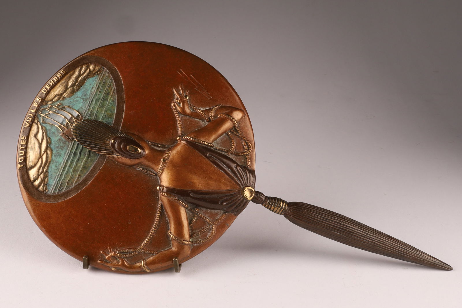 Romain de Tirtoff Erte (Russian/French, 1892-1990) Signed Art Deco Bronze 'All Sails Out' vanity: Romain de Tirtoff Erte (Russian/French, 1892-1990), 1985. Cold painted bronze art deco style "Toutes Voiles Dehors" hand mirror depicting a woman draped in pearls facing a ship in the distance. Signat