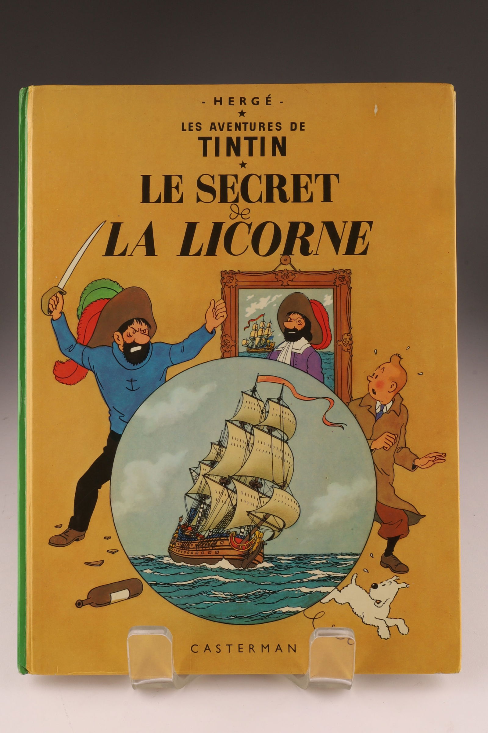 Signed Herge Aventures de Tintin Book: Signed and Inscribed iwth Drawing, Herge Les Aventures de Tintin, Le Secret La Licorne 1947. Inscription dated 1979. Some staining to pages, wear to spine. Measuring 12 x 9 inches.
