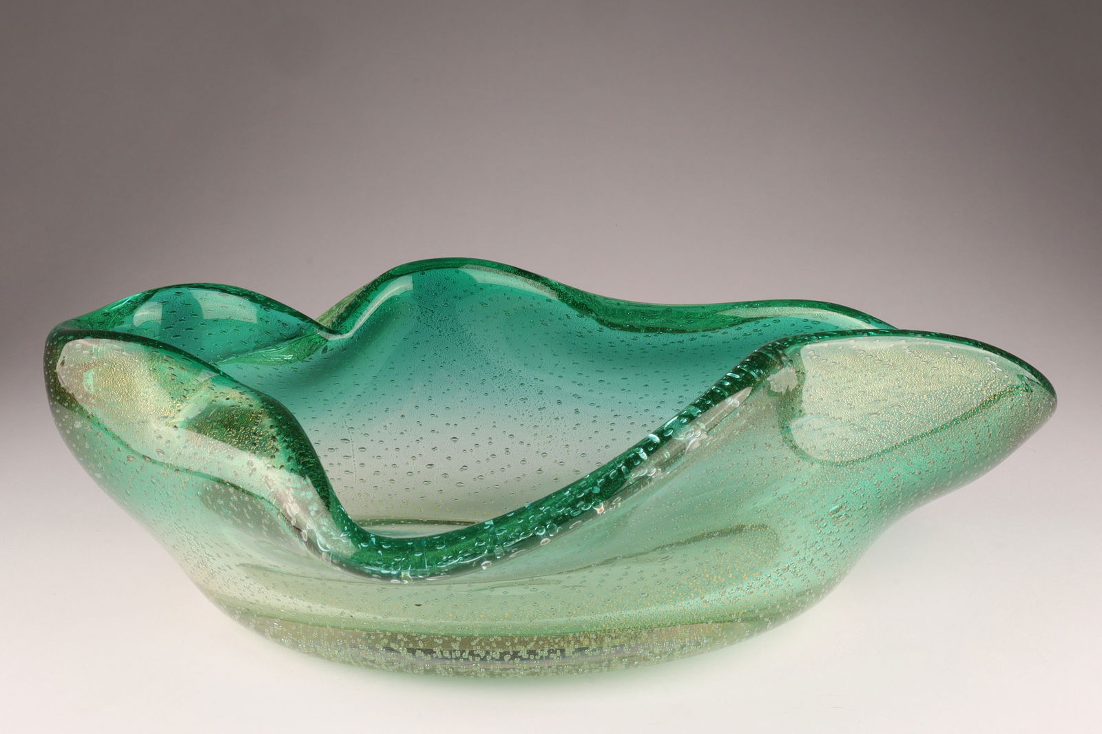 SEGUSO Murano Ruffled Bowl, Emerald Green with Gold: This Seguso bowl dates to the 1950s, with controlled bubble pattern and freeform edge. Measuring 13 inches L x 9 W x 4 H. From the collection of a prominent glass collector from Toronto.
