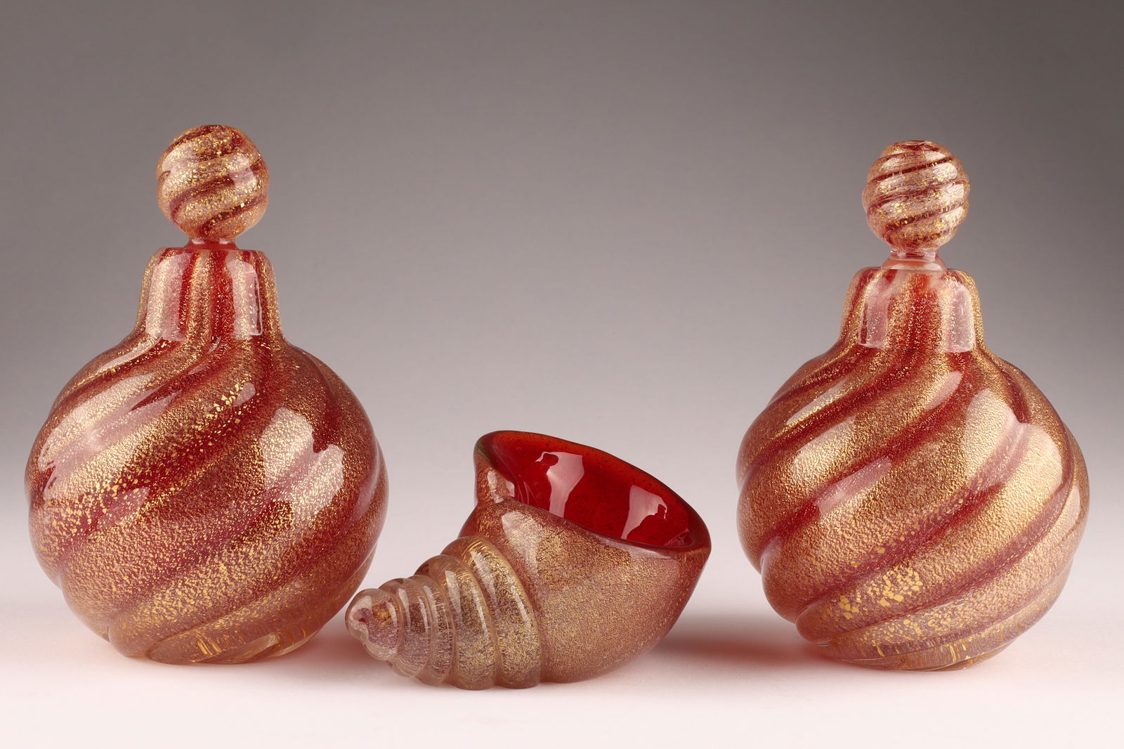 ARCHIMEDES SEGUSO Murano Art Glass Perfume Set, Ruby Red: This Archimedes Seguso perfume set dates to the 1950s. Set composed of two stoppered bottles and a shell form pin dish. Ruby red with gold inclusions. Bottles measure 5 inches H x 3.25 W. From the col