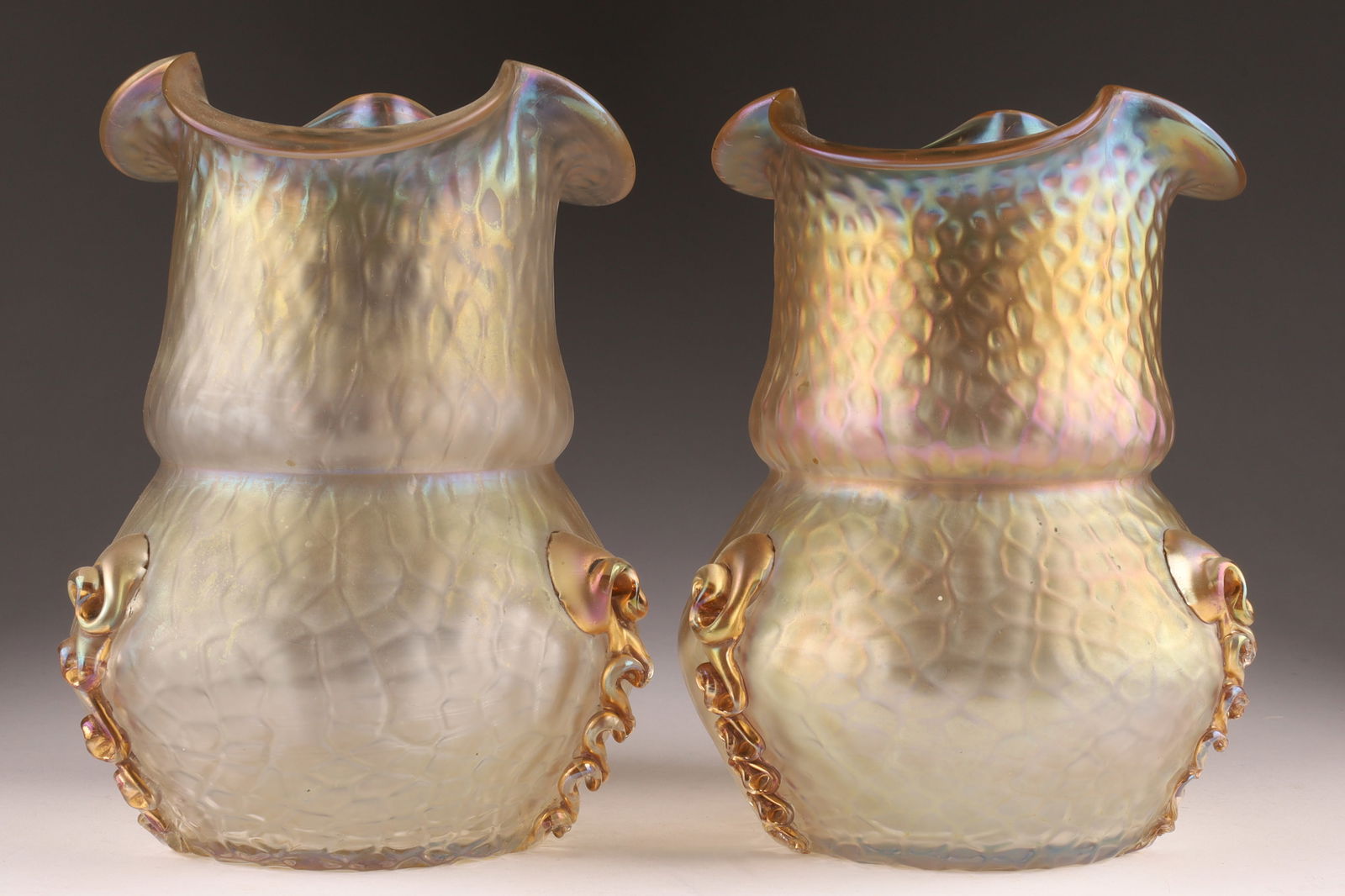 Pair of Kralik Art Nouveau Iridescent Glass Martele Vases: Pair of Kralik Art Nouveau Iridescent Glass Martele Vases. Some chips to applied ribbons. Measuring 6.5 inches H x 5 W.
