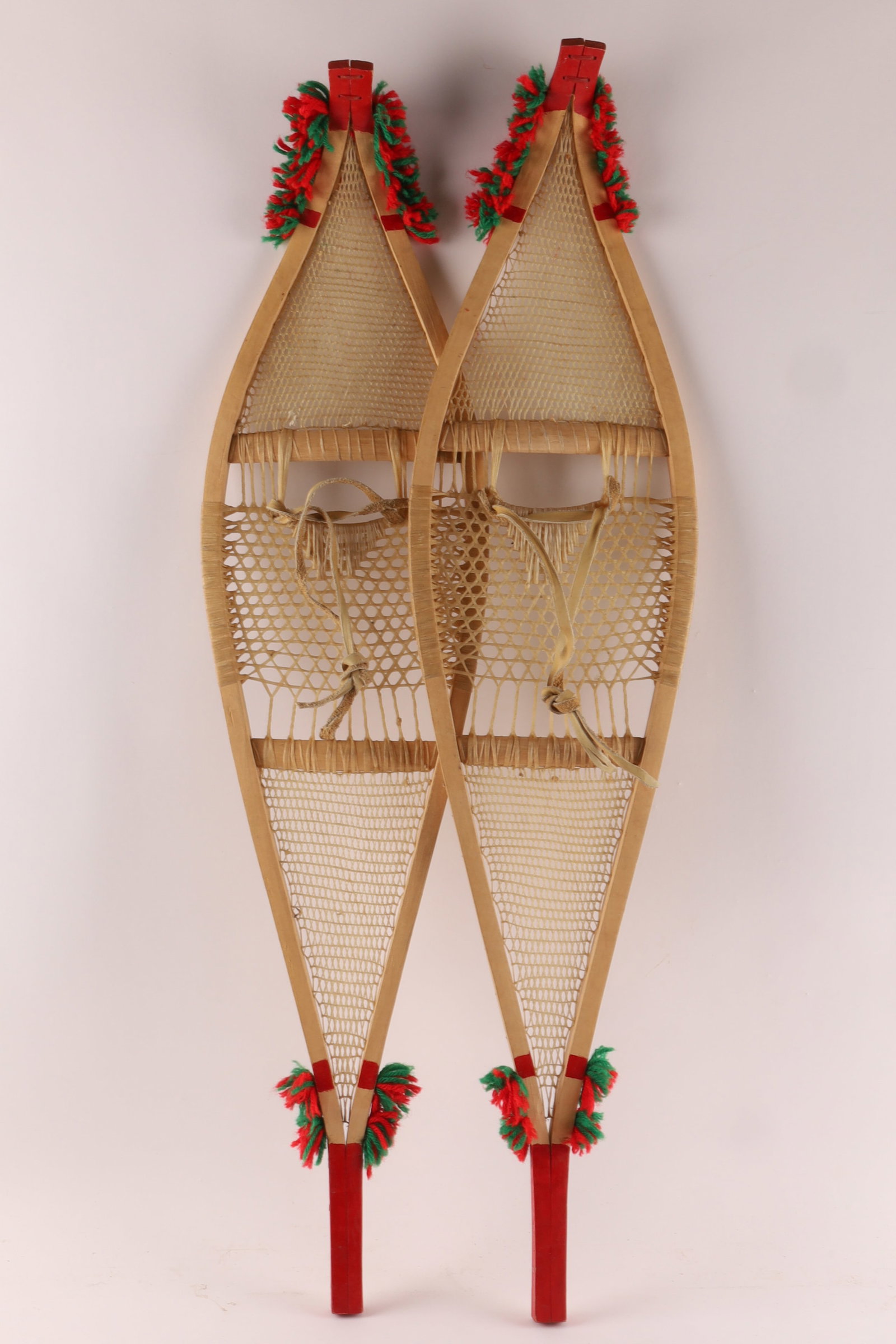 Vintage 1960s Pair Native Cree Indian Pom Pom Snowshoes: Vintage 1960s Pair Native Indian Cree Pom Pom Snowshoes, Ojibwa Style. Decorated with red and green yarn pompoms, red painted tips. Measuring 37 inches L x 8.5 W.