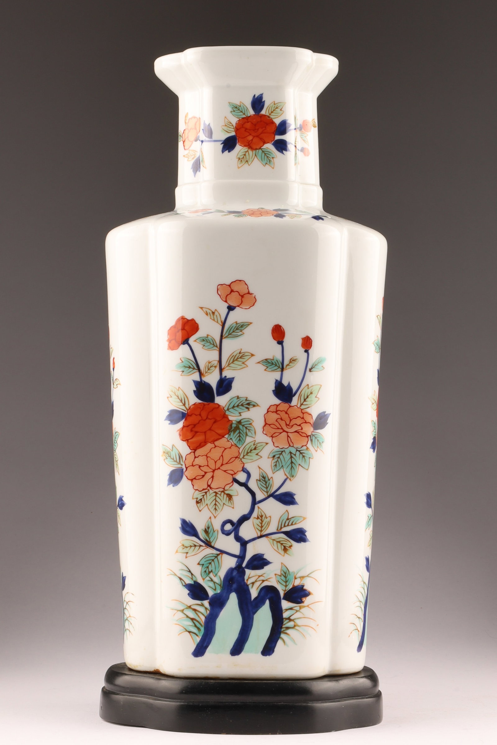 Large Japanese Porcelain Vase, Floral Decoration: Tall Japanese porcelain vase of faceted baluster form, decorated with stylized floral sprays in iron red, cobalt blue, and green enamels on a cream ground. The composition features flowering branches