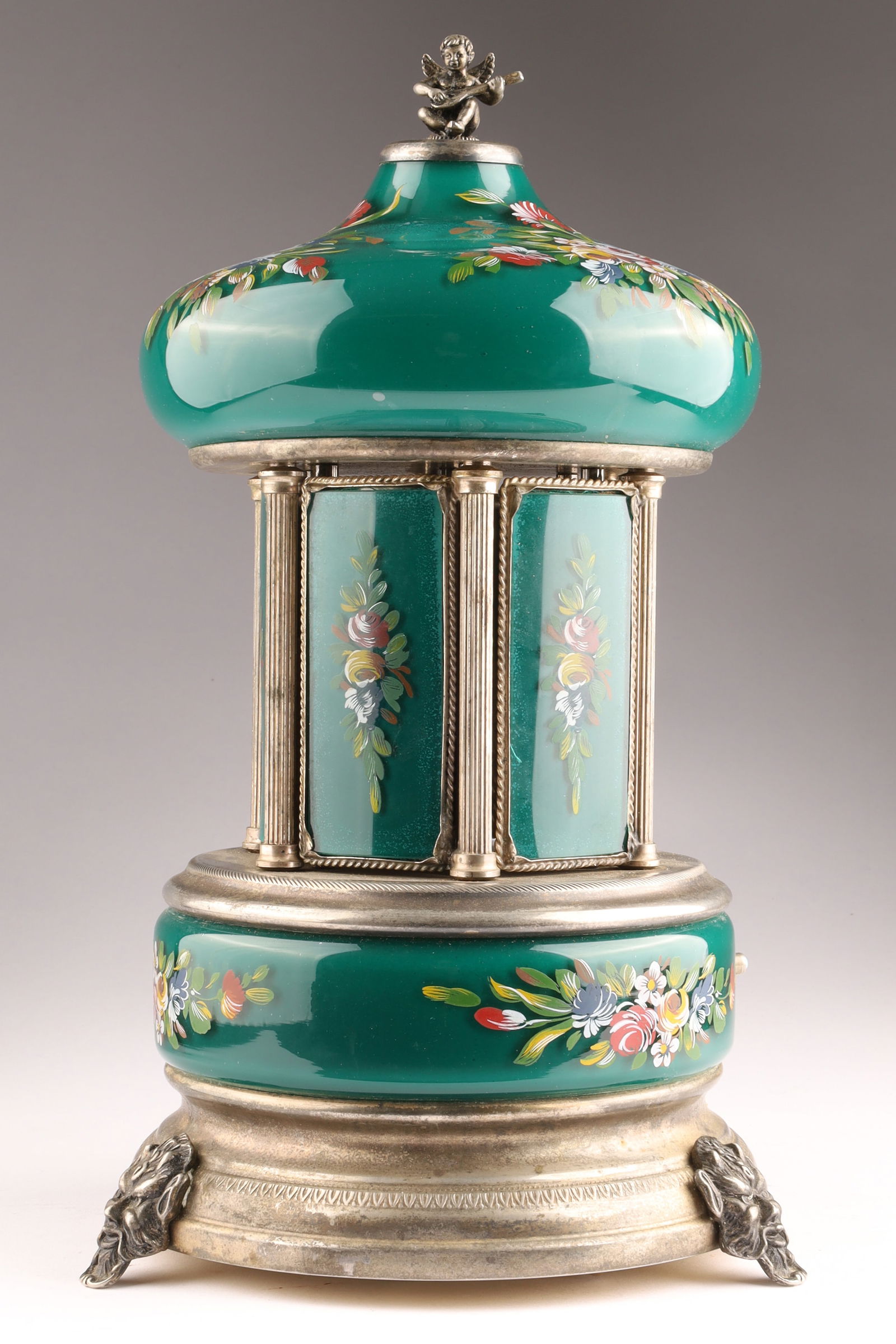 Antique REUGE Swiss Musical Carousel Cigarette Holder in Green Glass and Metal.: Decorative REUGE Swiss musical carousel-form cigarette holder or table automaton, featuring a domed green glass canopy and matching lower panels, each finely painted with polychrome floral sprays. The