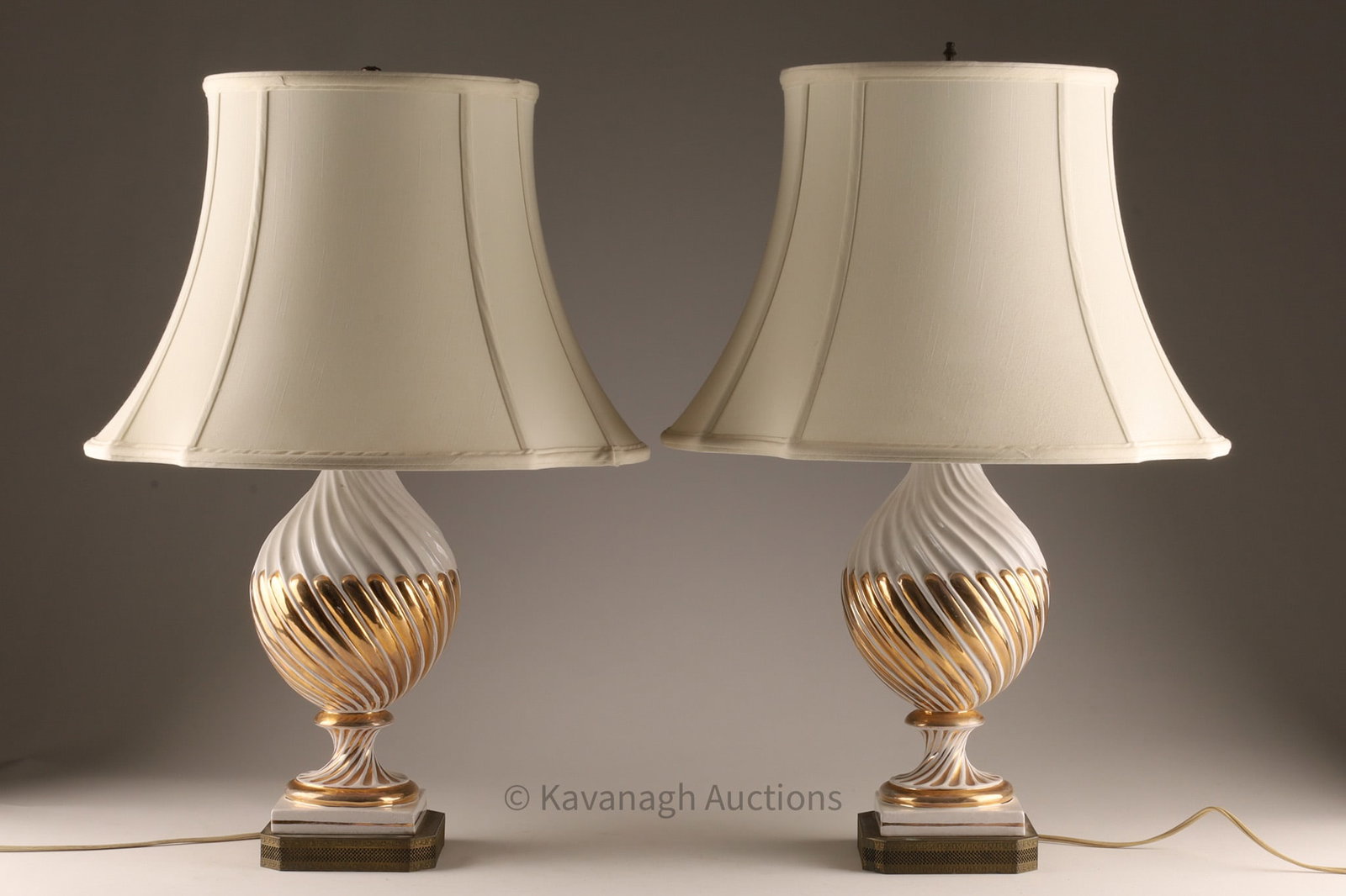 Pair of Italian Hollywood Regency White Porcelain Urn Lamps with Gold: Pair of Italian Hollywood Regency White Porcelain Urn Lamps with Gold Spiral Gadrooning mounted on square pierced brass bases, attributed to Ugo Zaccagnini, Florence. Measuring 24 inches H x 16