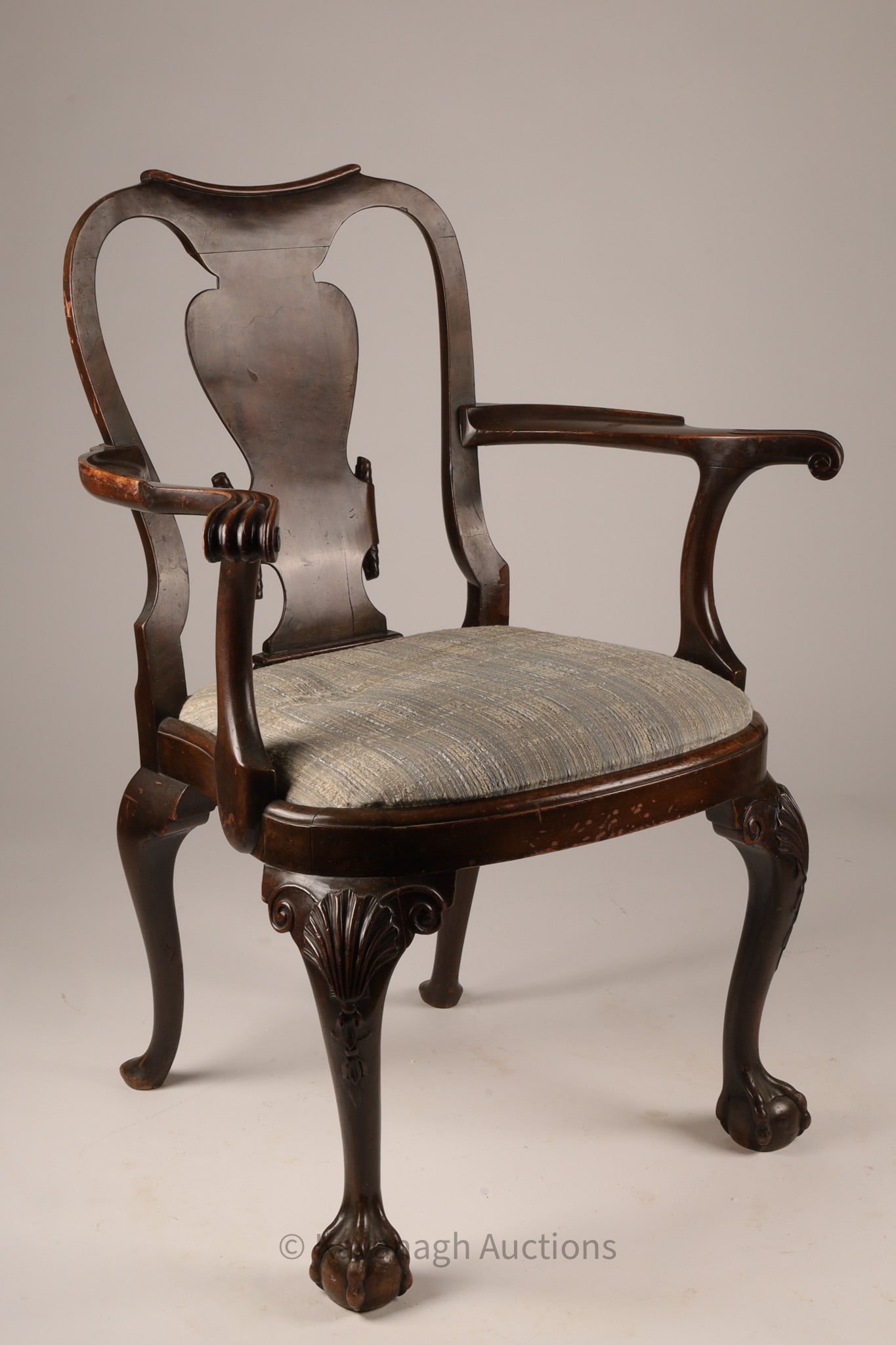 18th Century Queen Anne Style Mahogany Armchair Ball and Claw Feet: A finely carved armchair in the Queen Anne taste, executed in mahogany with a shaped crest rail and vasiform back splat. The chair features scrolling arms terminating in carved handholds, above a gene