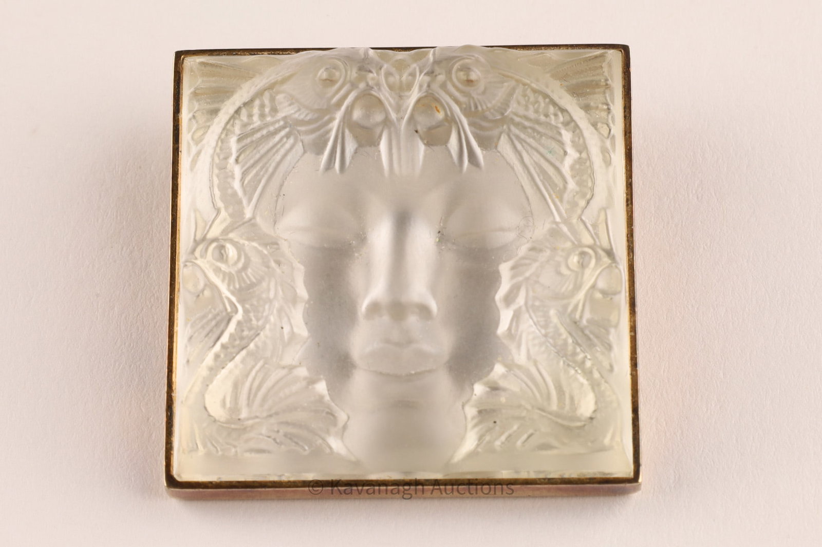 Lalique “Masque de Femme?? Crystal and Sterling Silver Brooch: Lalique brooch featuring a frosted crystal plaque molded in relief with the iconic “Masque de Femme” motif, depicting a serene female face framed by symmetrical birds and stylized foliage,