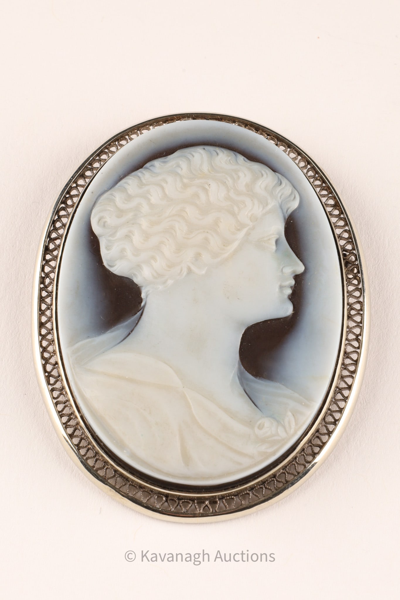 18K Gold Mounted Sardonyx (Onyx) Cameo Brooch, Classical Female Profile: Finely carved hardstone cameo brooch depicting a classical female profile in relief, executed in white against a dark ground, consistent with sardonyx (banded onyx). Details Medium: Sardonyx