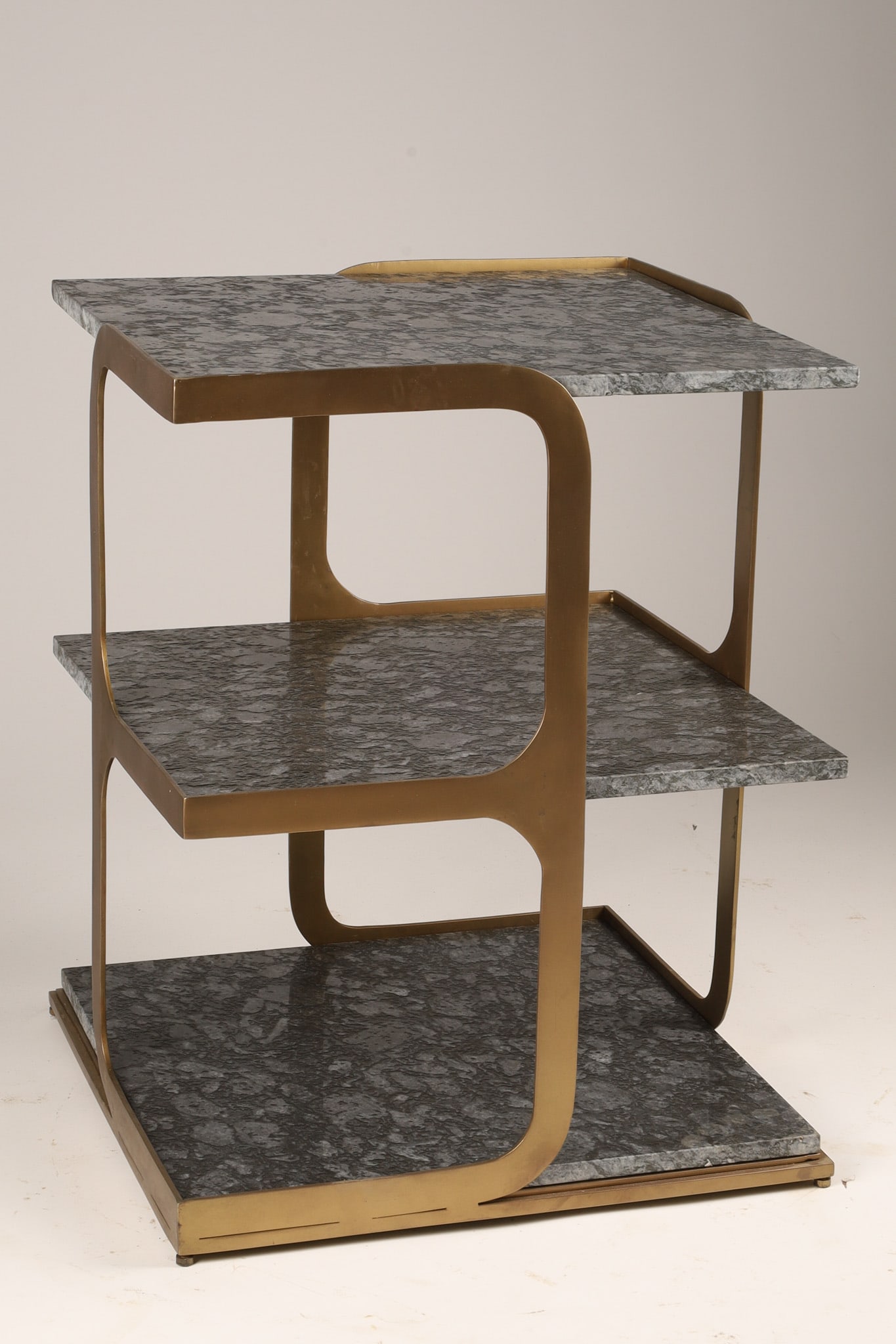 Modernist Three Tier Brass and Granite Side Table: A three-tiered modern accent table / side table or etagere, characterized by a gold-finished metal frame and granite surface. Dimensions: 24 inches H x 19.5 W x 19.5 deep.