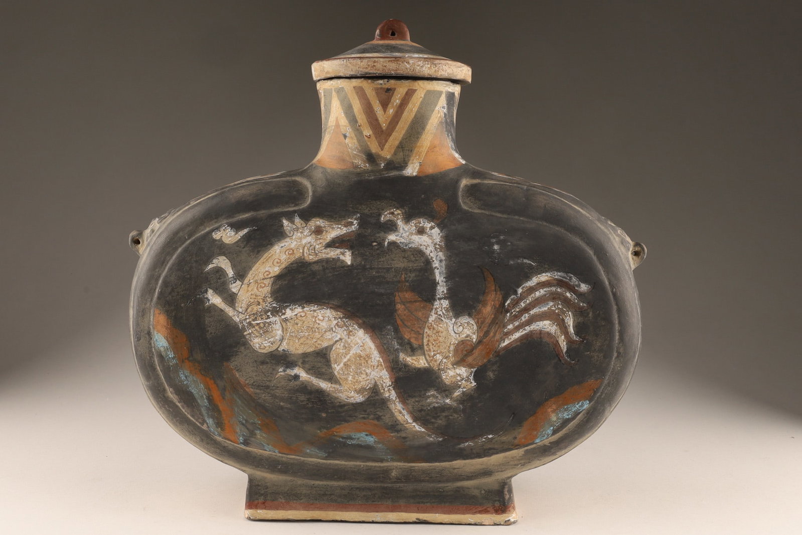 Han Dynasty Style Chinese Ceramic Vase After the Antique: A replica Chinese ceramic painted vase after the antique, depicting two mythical creatures, in tones of grey, white, red and gold. Vessel Type: a moon flask or a lentoid aryballos due to its