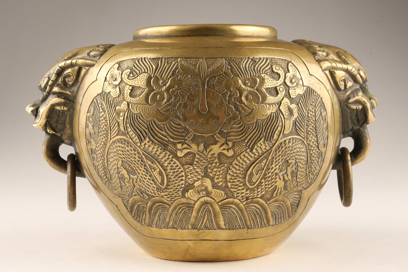 Antique Chinese Bronze Censer Pot Hand Chased Dragons and Ring Handles Signed: An antique Chinese bronze incense burner pot, with cast relief decorations of flying dragons within clouds and animal-shaped head handles with dangling rings. Xuande mark on underside Material: