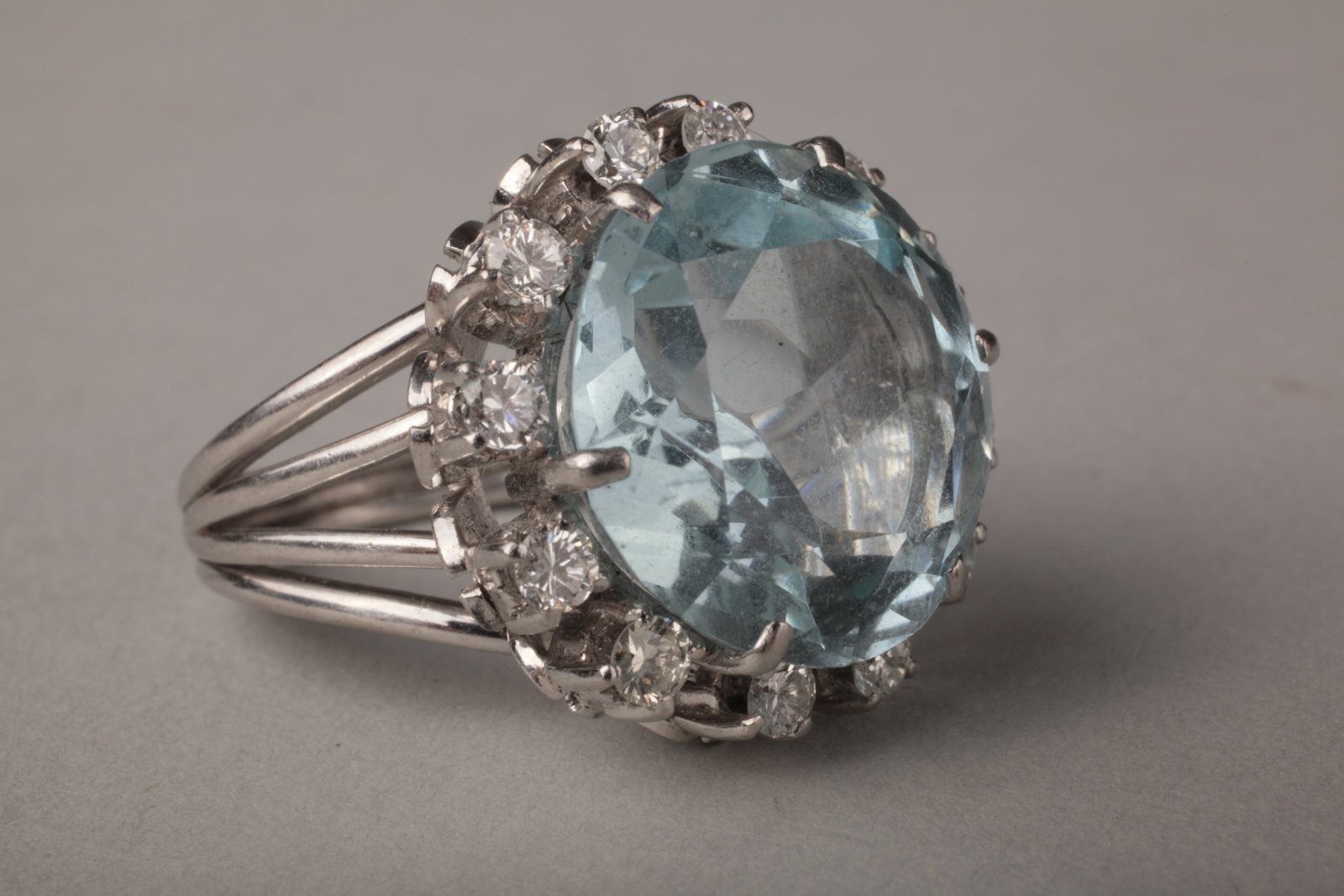 Mid-Century 18K White Gold Aquamarine & Diamond Cocktail Ring, c. 1950–60s: Substantial mid-century / MCM 18 karat white gold aquamarine and diamond cocktail ring, circa 1950–60s, centered with a large pale blue modified round brilliant-cut aquamarine measuring approximatel