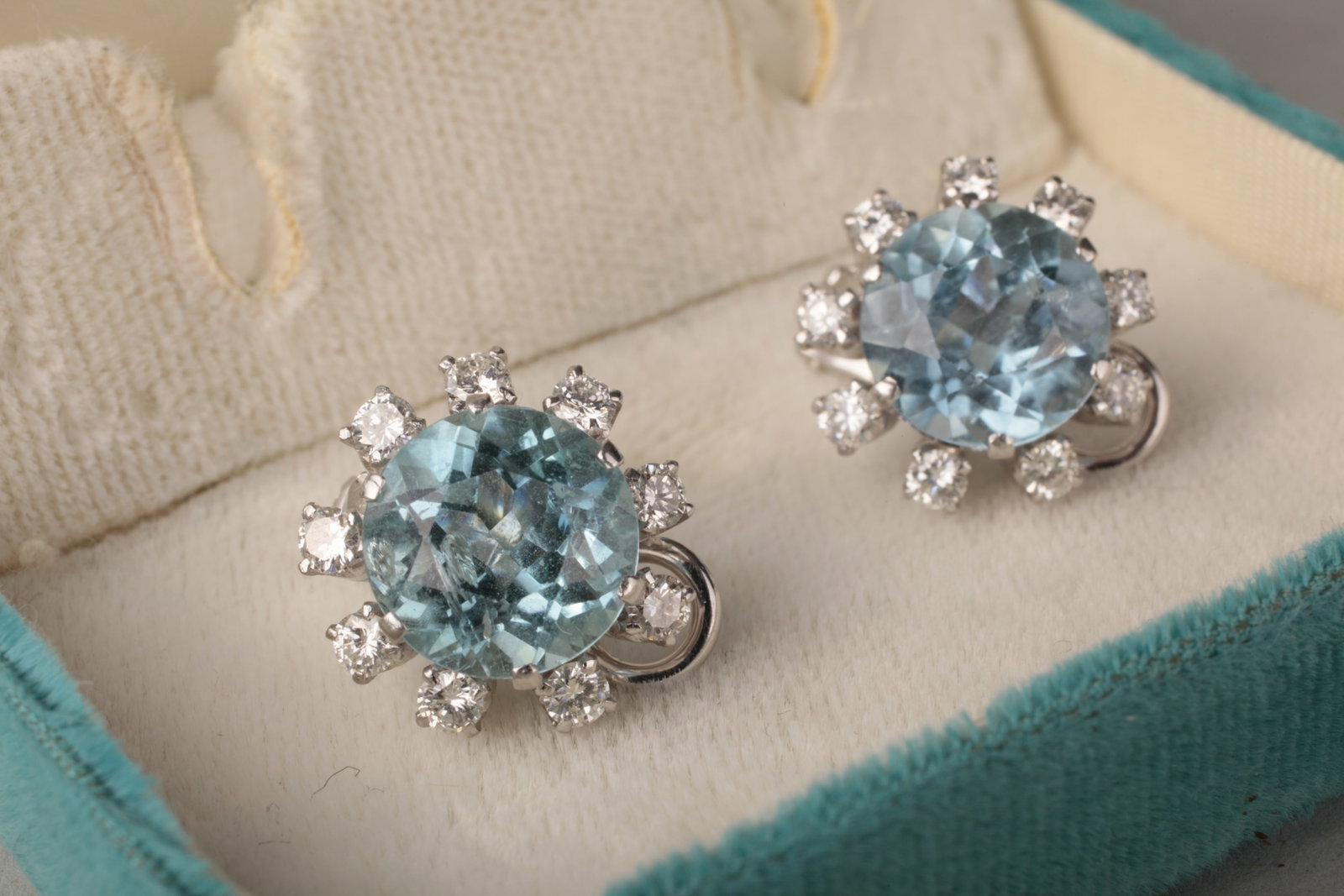 Mid-Century 18K White Gold Aquamarine & Diamond Clip Earrings, c. 1950–60s: Pair of mid-century / MCM 18K white gold aquamarine and diamond clip earrings, circa 1950–60s, each centered with an oval faceted aquamarine measuring approximately 10 × 7 mm, estimated at approxim