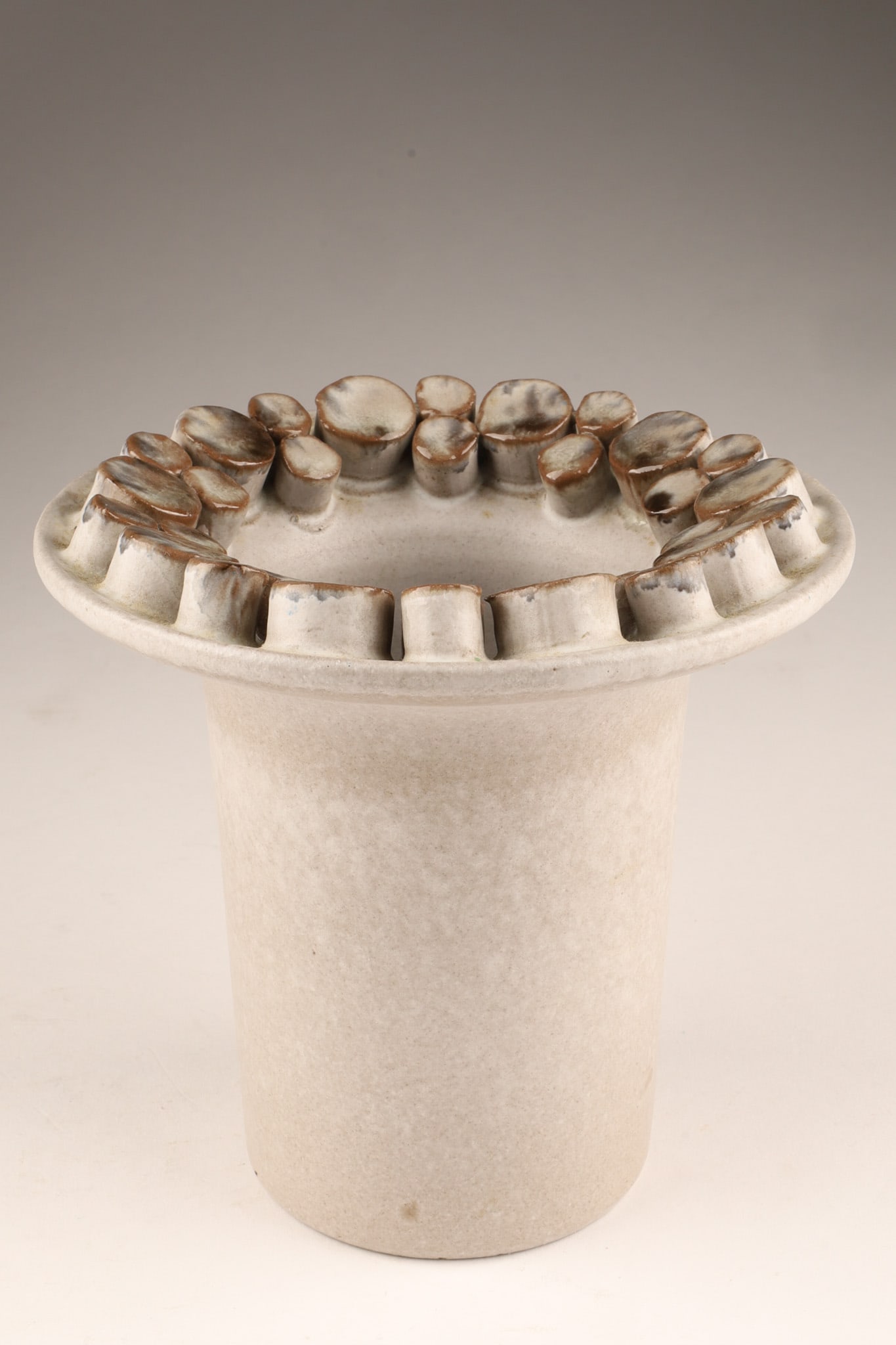 Mid Century Germany Ceramano Ceralux Hans Welling Vase: Mid Century Germany Ceramano Ceralux Hans Welling Vase, featuringa grey finish and a distinctive textured rim resembling stacked cylinders. Signed on underside. Dimensions: 5.5 inches H x 5.5 W.