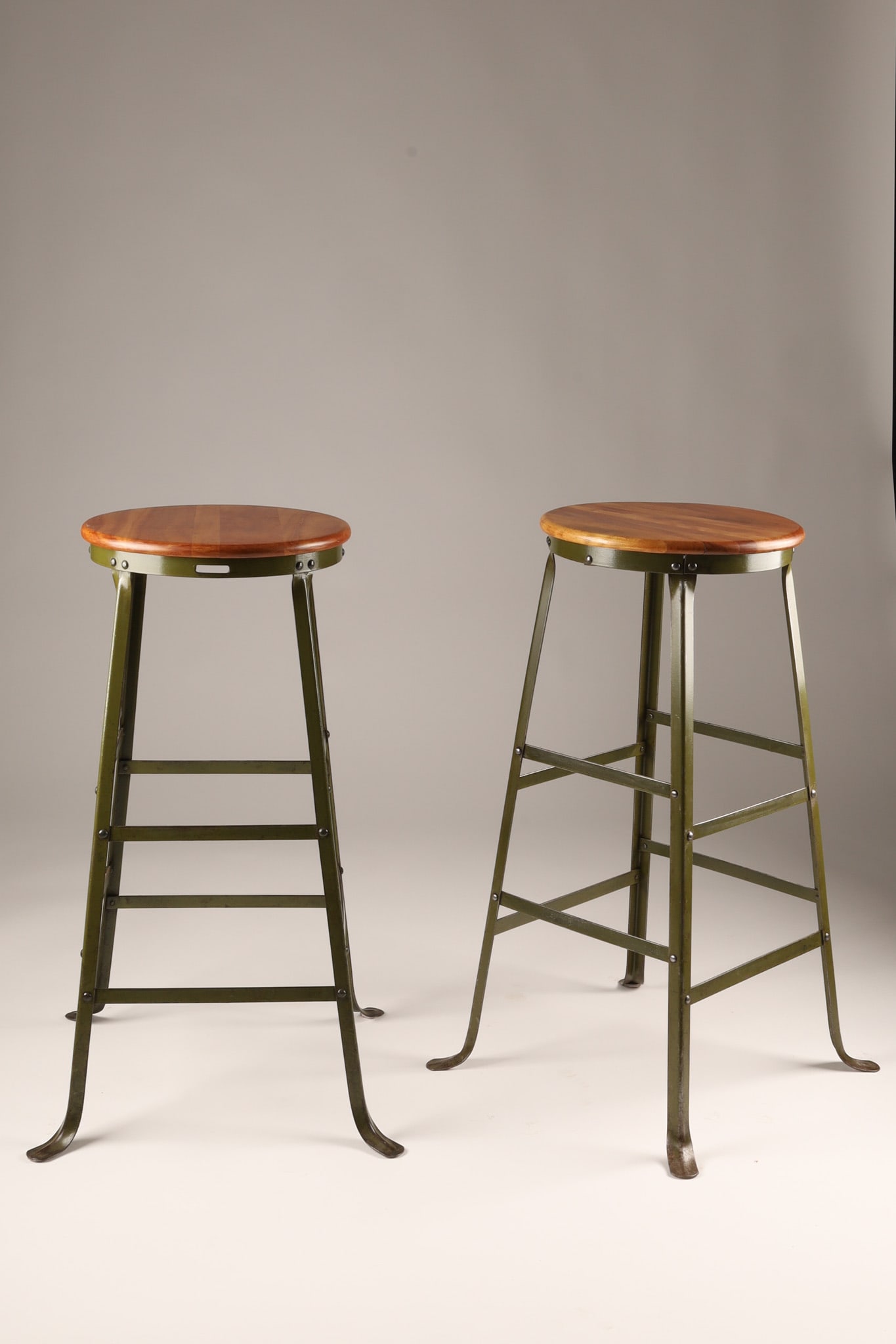 Pair of Mid Century Industrial Superior Co Fergus Drafting Stools: Pair of Mid Century vintage industrial stools featuring a steel frame with iconic splayed feet and a maple seat, manufactured by the Superior Barn Equipment Company (also known as Superior Co) based i