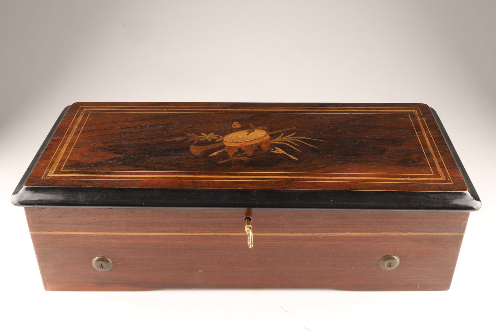 Antique Swiss Cylinder Roll Music Box in Marquetry Box: An antique Swiss cylinder music box, likely dating to around 1880.The mechanism is housed in a rosewood case, featuring a brass cylinder and a steel comb for producing sound. Functioning. Dimensions: 