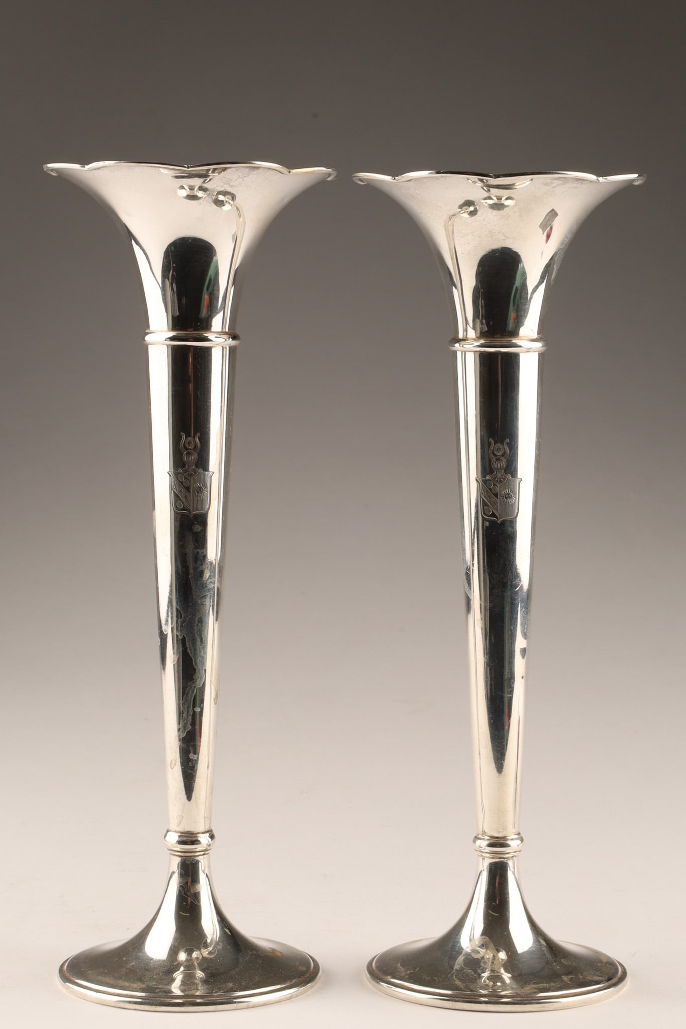 Pair of Tiffany and Co Sterling Silver Trumpet Bud Vases: A pair of Tiffany and Co. sterling silver bud vases, in the trumpet form with a fluted rim from the early-to-mid 20th century. With Armorial shield engraved on fronts. Marked on underside Tiffany and 