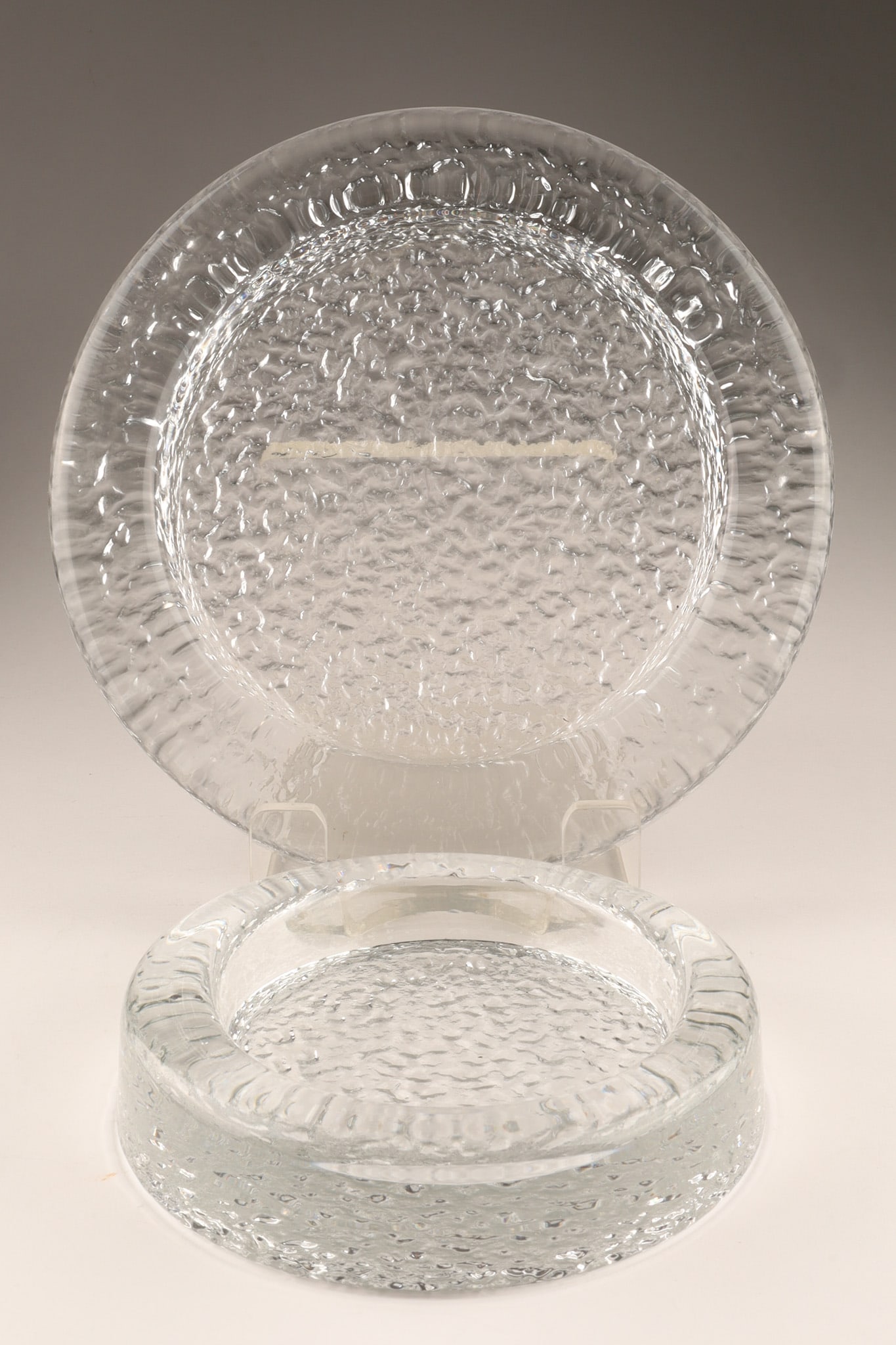 Pair of Mid Century Iittala Riite Glass Bowls Finland Timo Sarpaneva: Pair of Mid Century Iittala Riite ashtray / glass bowls designed by Timo Sarpaneva in the 1960s, featuring a textured, ice-like surface. Dimensions: LArge measures 9.5 inches W x 1.5 H, small measures