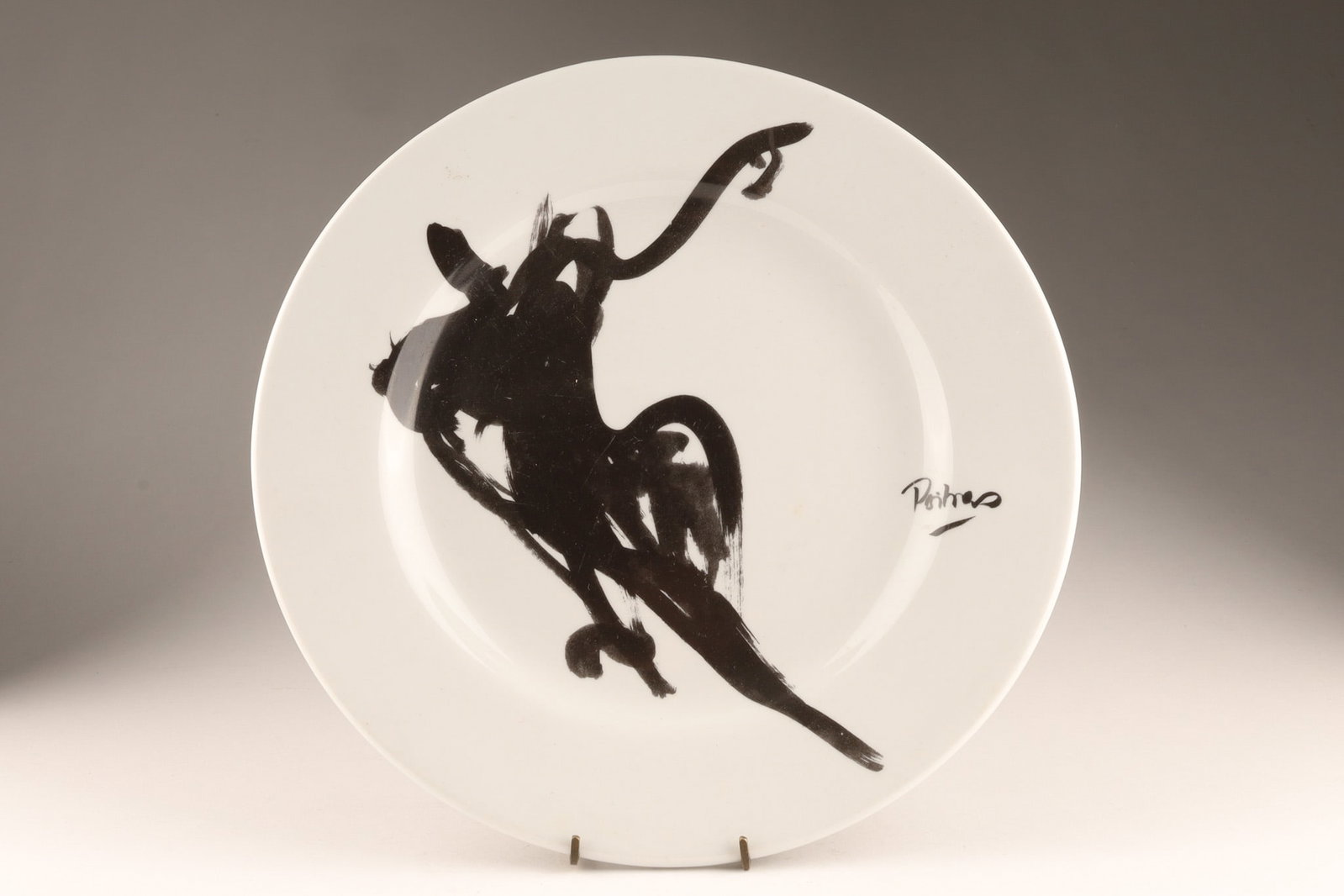 Jean-Claude Poitras Decorative Plate with Minimalist Figural Design: A decorative plate featuring an abstract figural design by Jean-Claude Poitras, a renowned Canadian fashion designer and multidisciplinary artist. Marked on back of plate and next to image. Known prim