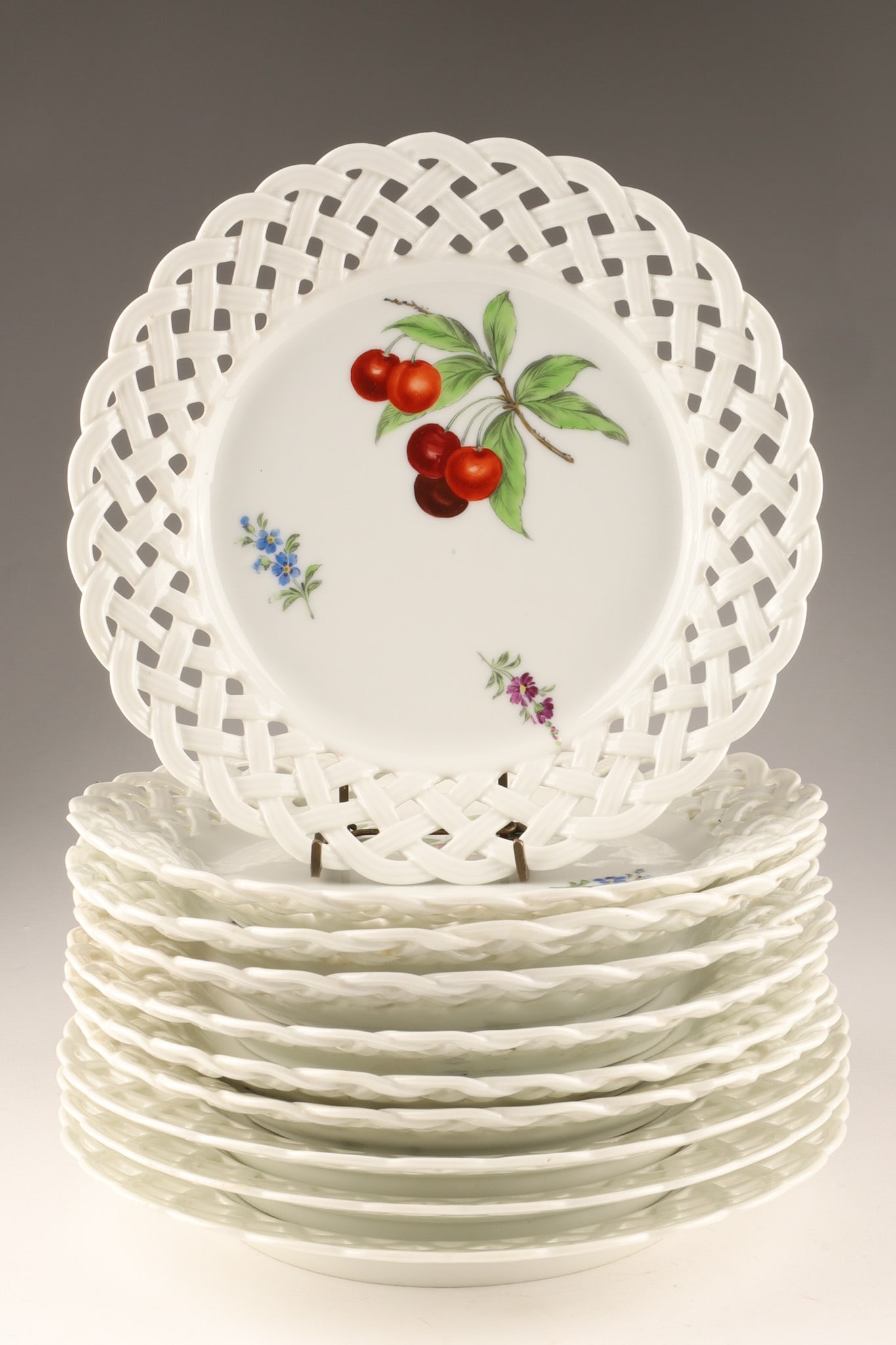 Set of Antique Meissen Porcelain Reticulated Fruit Plates: Near Set of Antique Meissen Porcelain Reticulated Fruit Plates. They feature openwork basket weave borders and are hand-painted with various fruits and small florals, marked on underside with crossed 