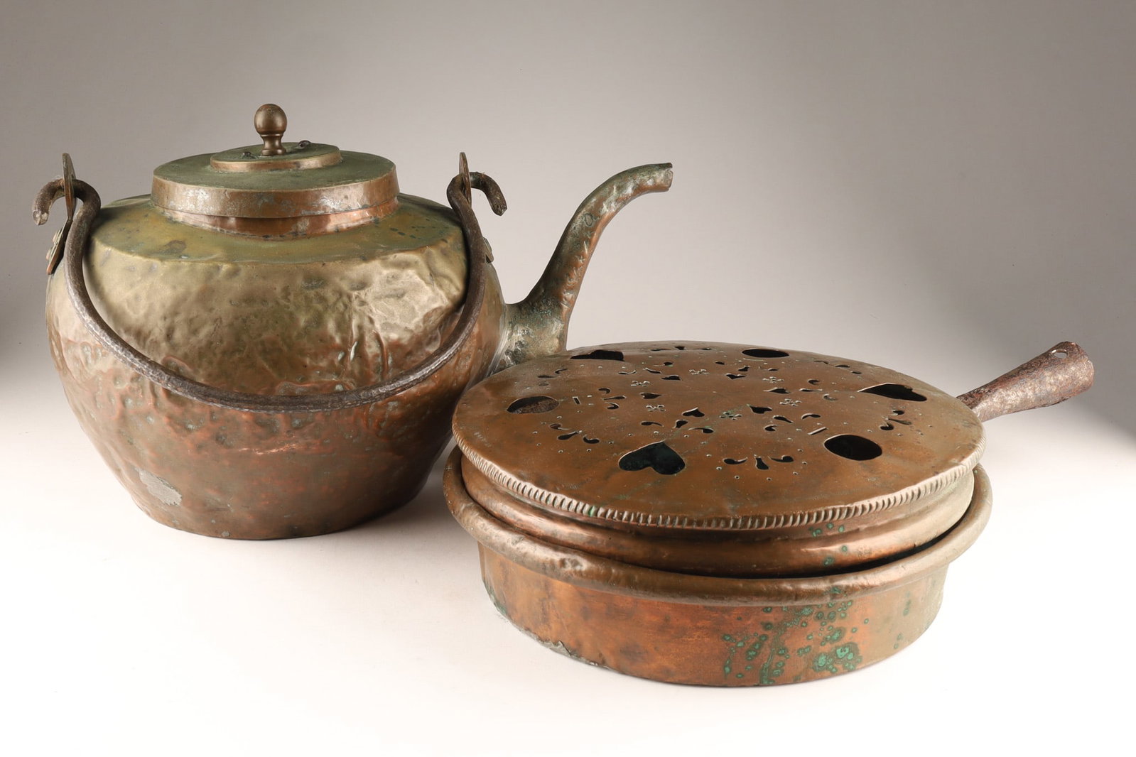 Very Large Antique Hand Hammered Copper Kettle and Bed Warming Pan: Antique Hand Hammered Copper Kettle with cast iron handle, and Bed Warming Pan decorated with heart cut outs and geometric design. Dimensions: Kettle measures 12 inches H x 15 W, bed warming pan