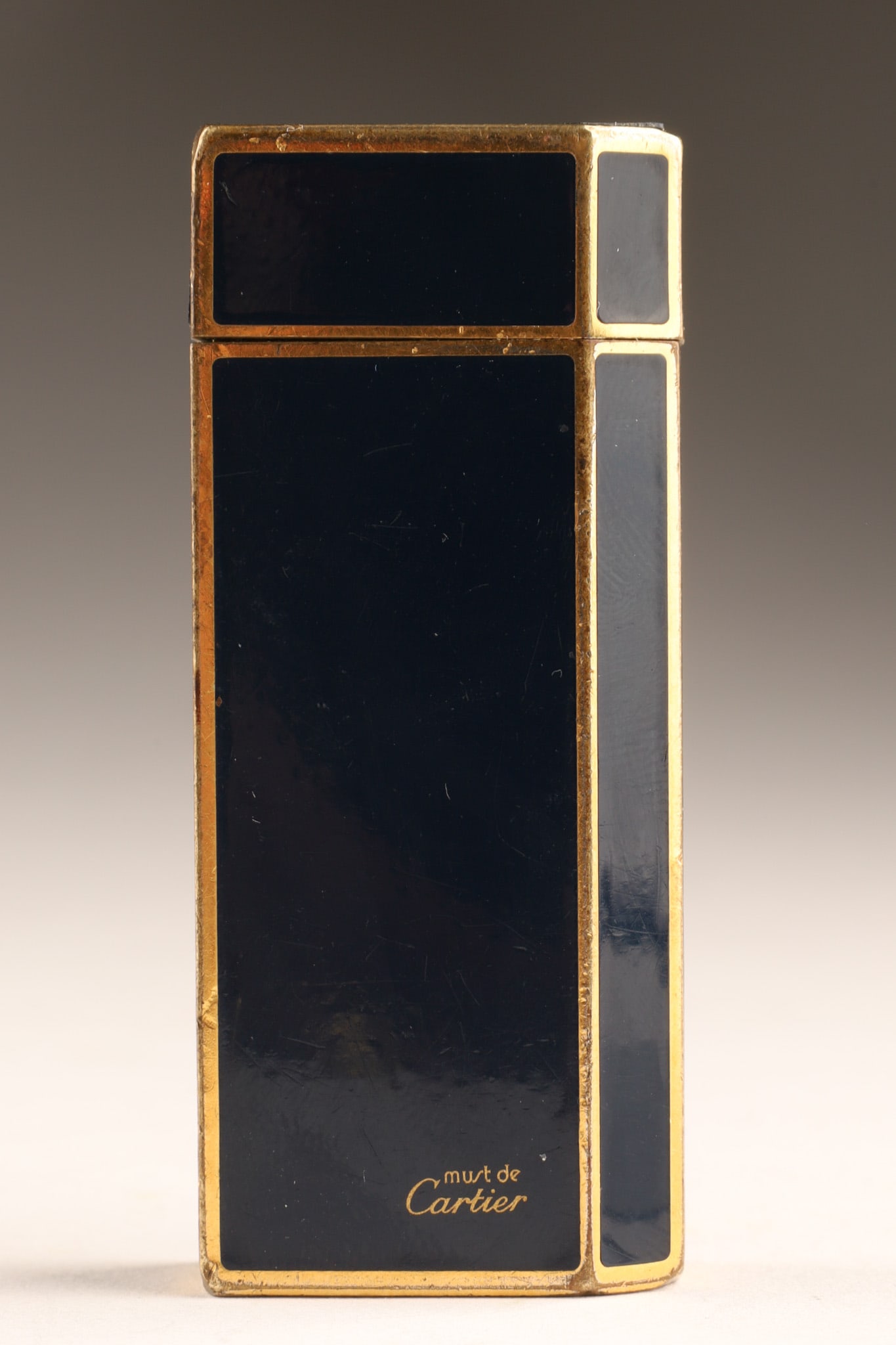 Vintage Gold Tone and Enamel Must De Cartier Lighter: A vintage Must de Cartier gold plated trim lighter, signed Cartier Paris, Swiss Made, serial number on base. Height: 1.97 in (50 mm) Width: 0.99 in (25 mm) Depth: 0.48 in (12 mm). 