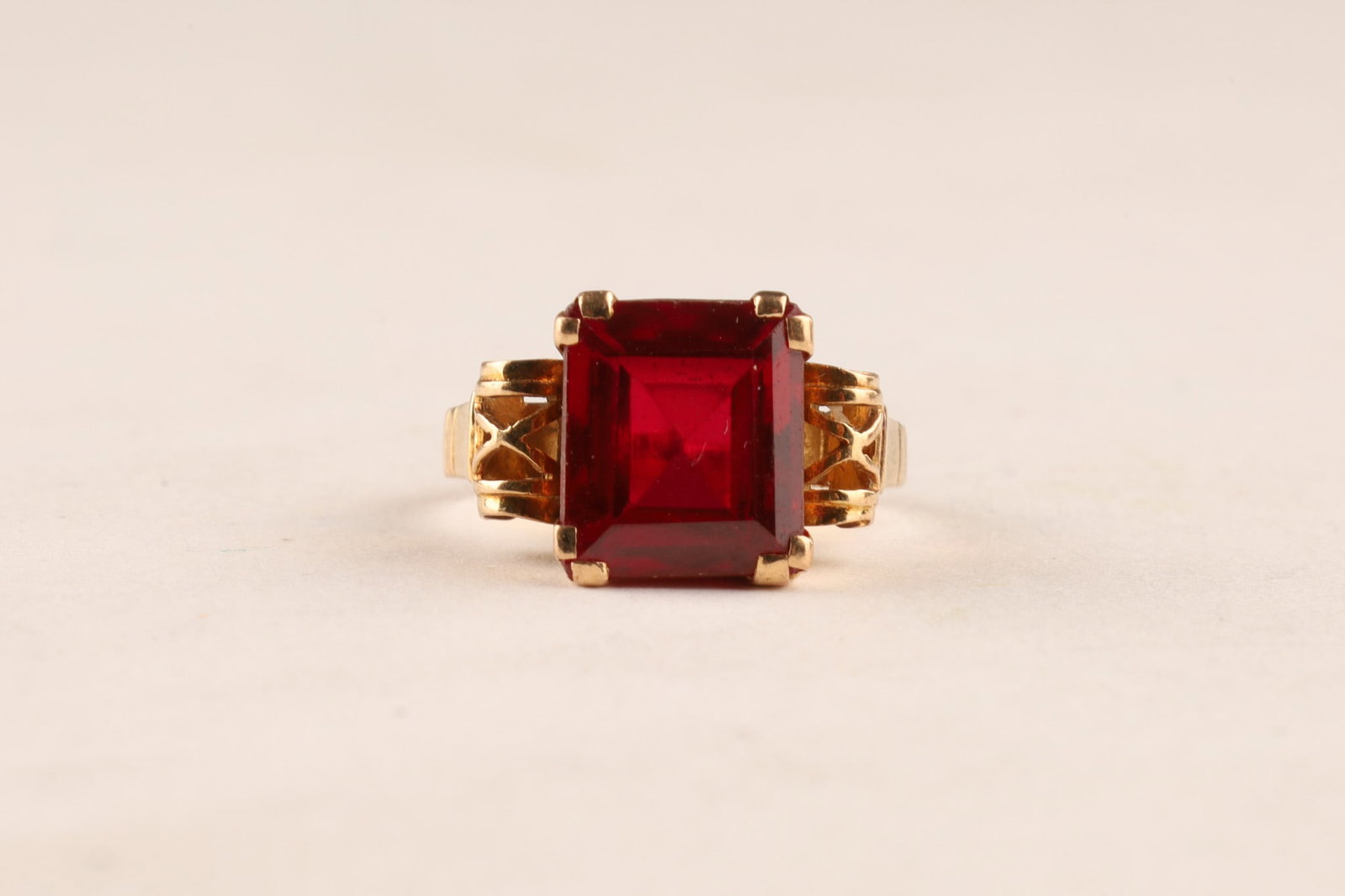 14K Gold and Pigeon Blood Red Ruby Ring, Size 4.75: 14K Gold Ring with Synthetic Pigeon Blood Red Emerald Cut Ruby, In basket setting, mounted with four prongs. Size 4.75, 4.3 grams, stone measures 12mm x 10mm.