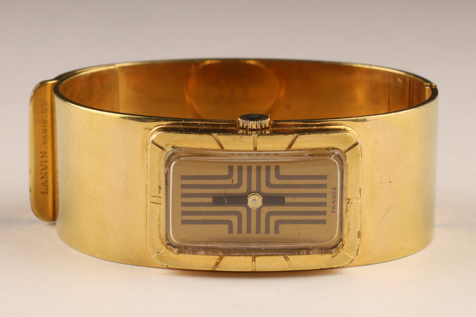 1970s Mid Century Modern Lanvin Paris Cuff Watch Bracelet de Force:  Rare Lanvin "Bracelet De Force" (also known as a cuff or bangle watch) from approximately 1970-1975. Gilt version of the iconic rectangular cuff design with cross pattern on the dial. Manual win