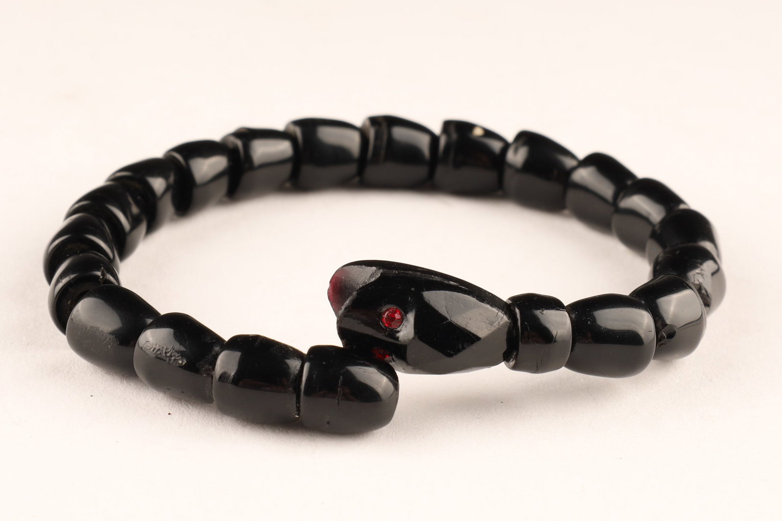 Late 1800s Victorian French Jet Snake Bracelet: An antique Victorian-style coiled serpent bracelet, measuring 8 inches in total length. It features individual segments of faceted black beads strung over an internal, flexible metal band. The termina