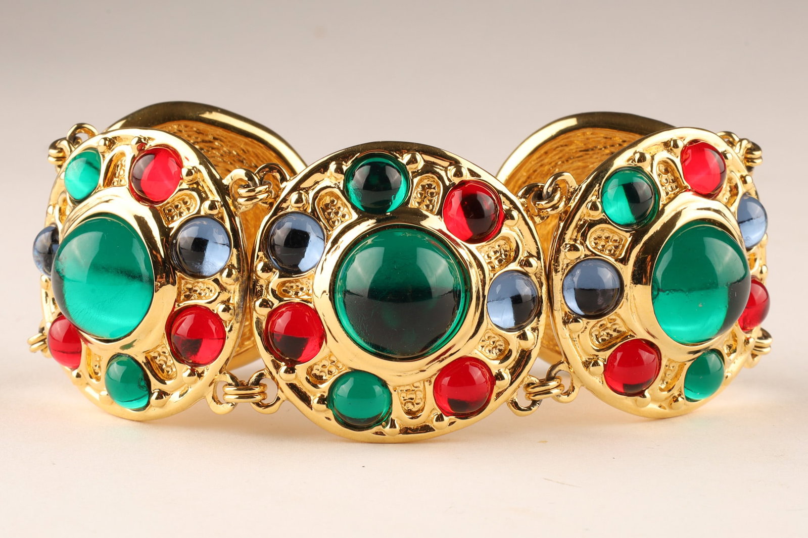 Christian Dior Tutti Frutti Costume Glass Bracelet: Christian Dior Vintage Tutti Frutti Glass Bracelet, featuring gold-tone articulated metal links heavily embellished with colorful, glass paste cabochons. The vibrant combination of oversized emerald g
