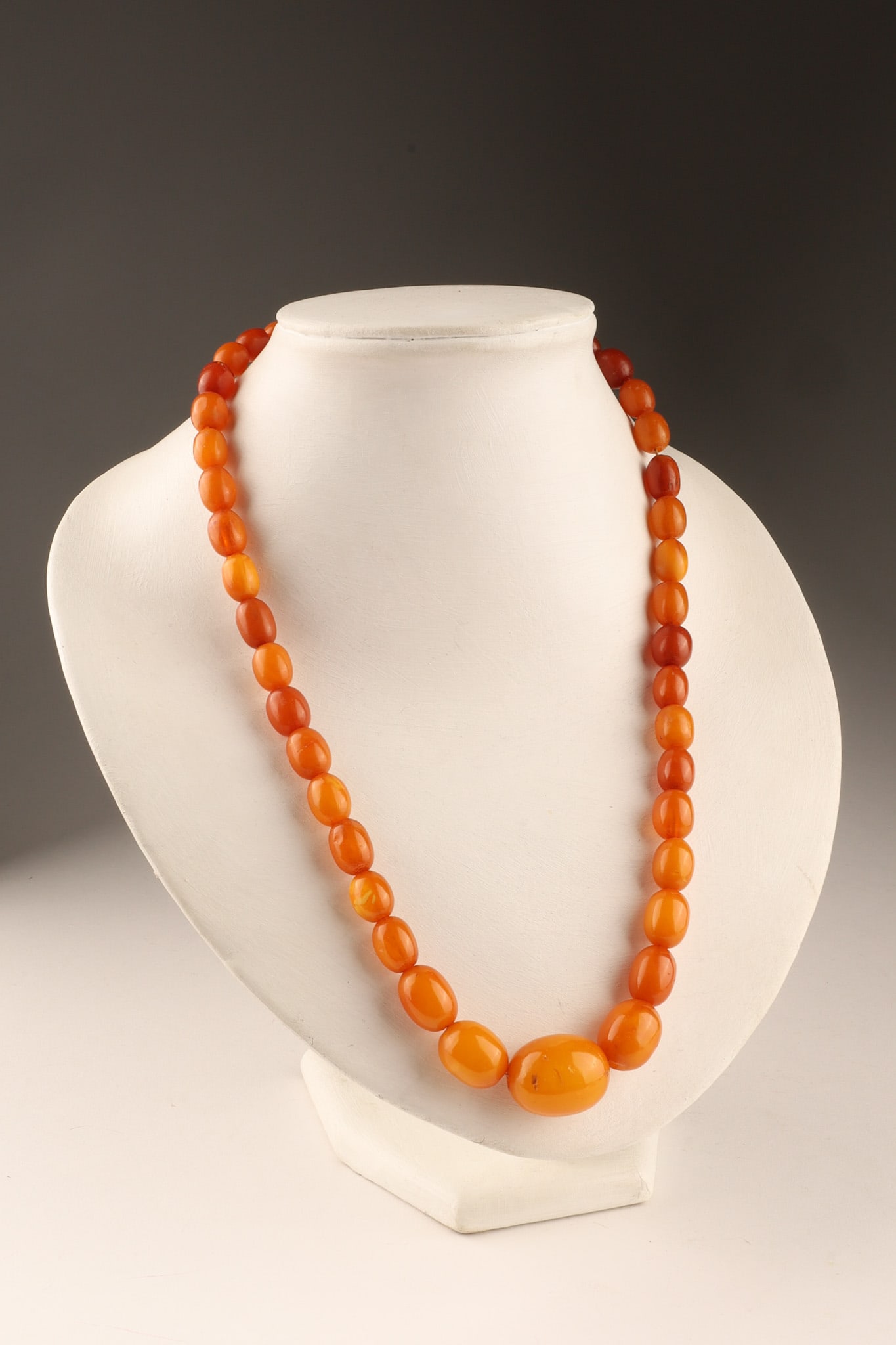 Antique Egg Yolk Colour Baltic Amber Graduated Beads Necklace: An antique Baltic amber necklace featuring graduated oval beads in a butterscotch or egg yolk color. Dimensions: 21.5 inches L.