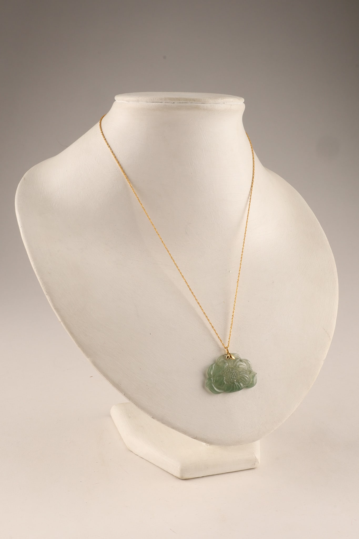 Chinese Jade Cloud Pendant Necklace on 18K Gold Chain: Chinese Jade Pendant Necklace on 18K Gold Chain, the pendant carved with a flower in a cloud shape, the chain marked AU750. Chain measures 18 inches, pendant measures 1.25 inches W x 1 H. Chain weighs