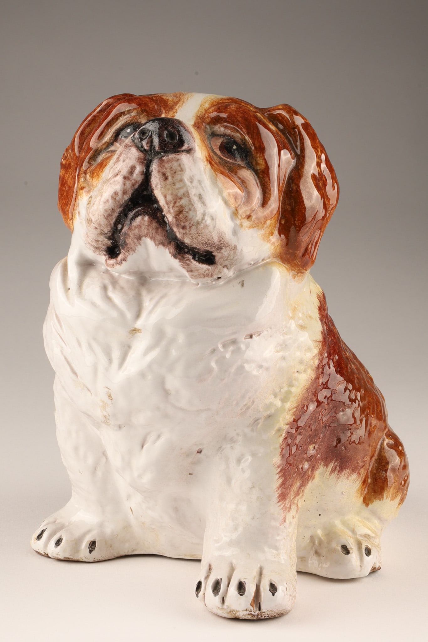 Hand Painted Ceramic Saint Bernard Dog, Made in Italy: A hand painted Saint Bernard ceramic dog, measuring 8 inches tall, 7.75 inches long and 5.75 wide. Marked Made In Italy on the base. 