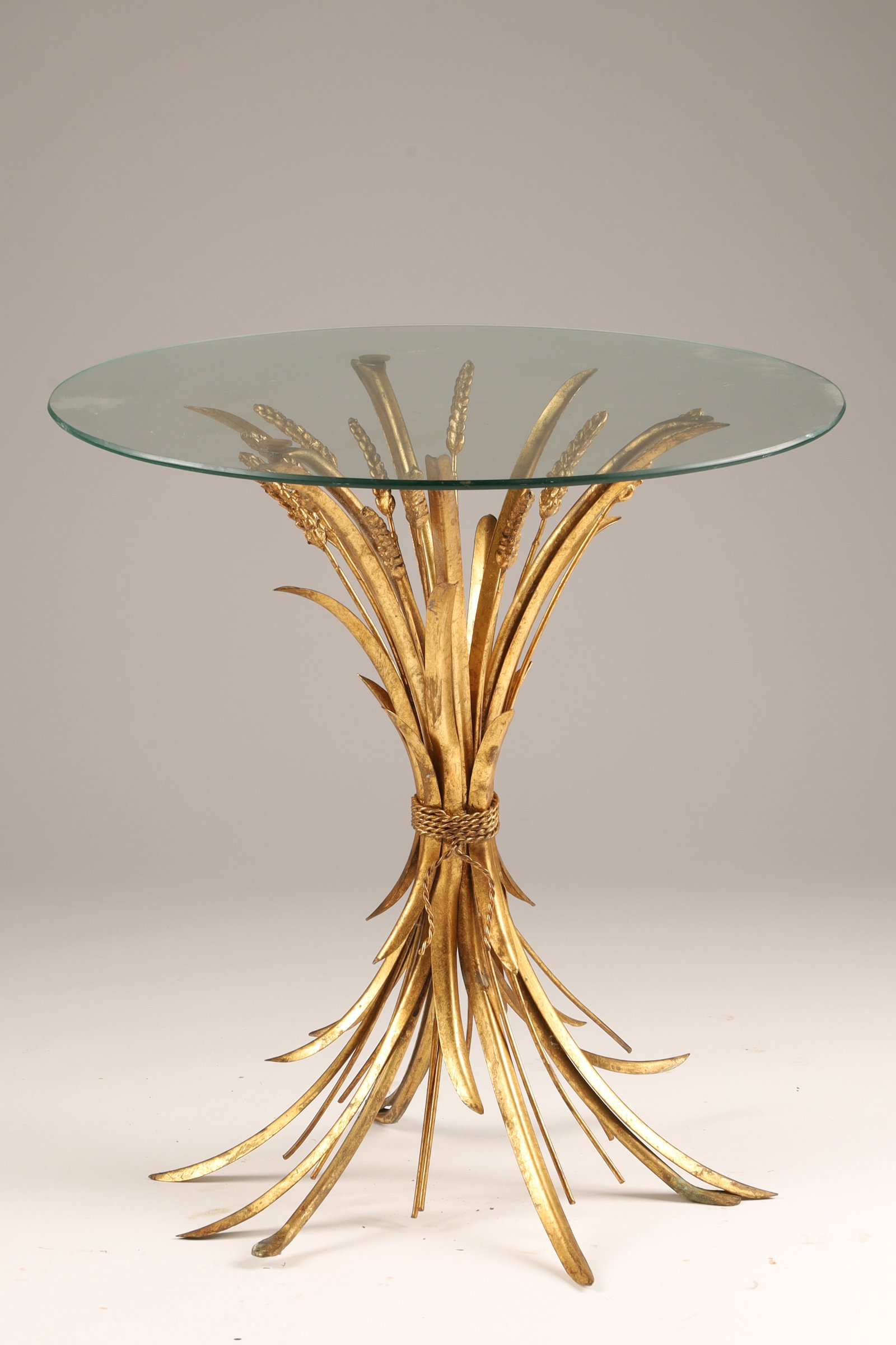 Mid Century Hollywood Regency Style Gilt Wheat Sheaf Side Table: A mid-20th-century Hollywood Regency-style gilt metal and glass wheat sheaf accent table attributed to Hans Kogl, a style famously owned by Coco Chanel. Measuring 22 inches H x 20 W.