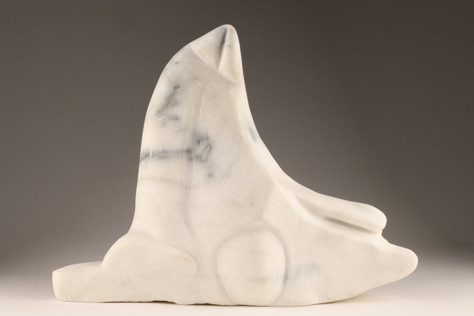Large Modernist Carved White Marble Sculpture: A contemporary biomorphic stone sculpture hand-carved from a single block of white marble, unsigned, featuring polished and softly textured surfaces with deep gray and charcoal veining. Measuring 15 i