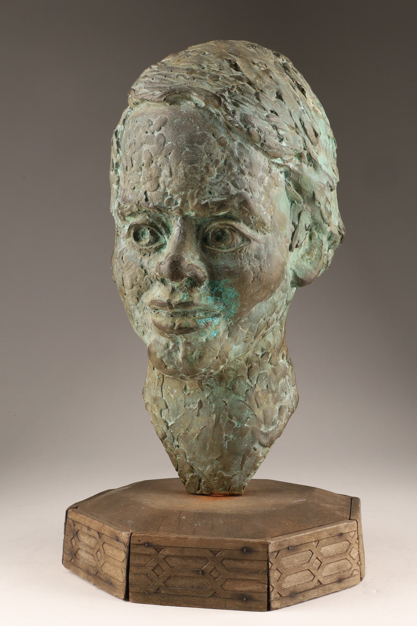 Modernist Bronze Portrait Bust of A Gentleman Signed: A Modenist impressionistic bronze portrait bust of a man featuring a highly textured, expressive surface treatment and an oxidized green-blue patina, mounted on a geometric, faceted wooden base. Initi