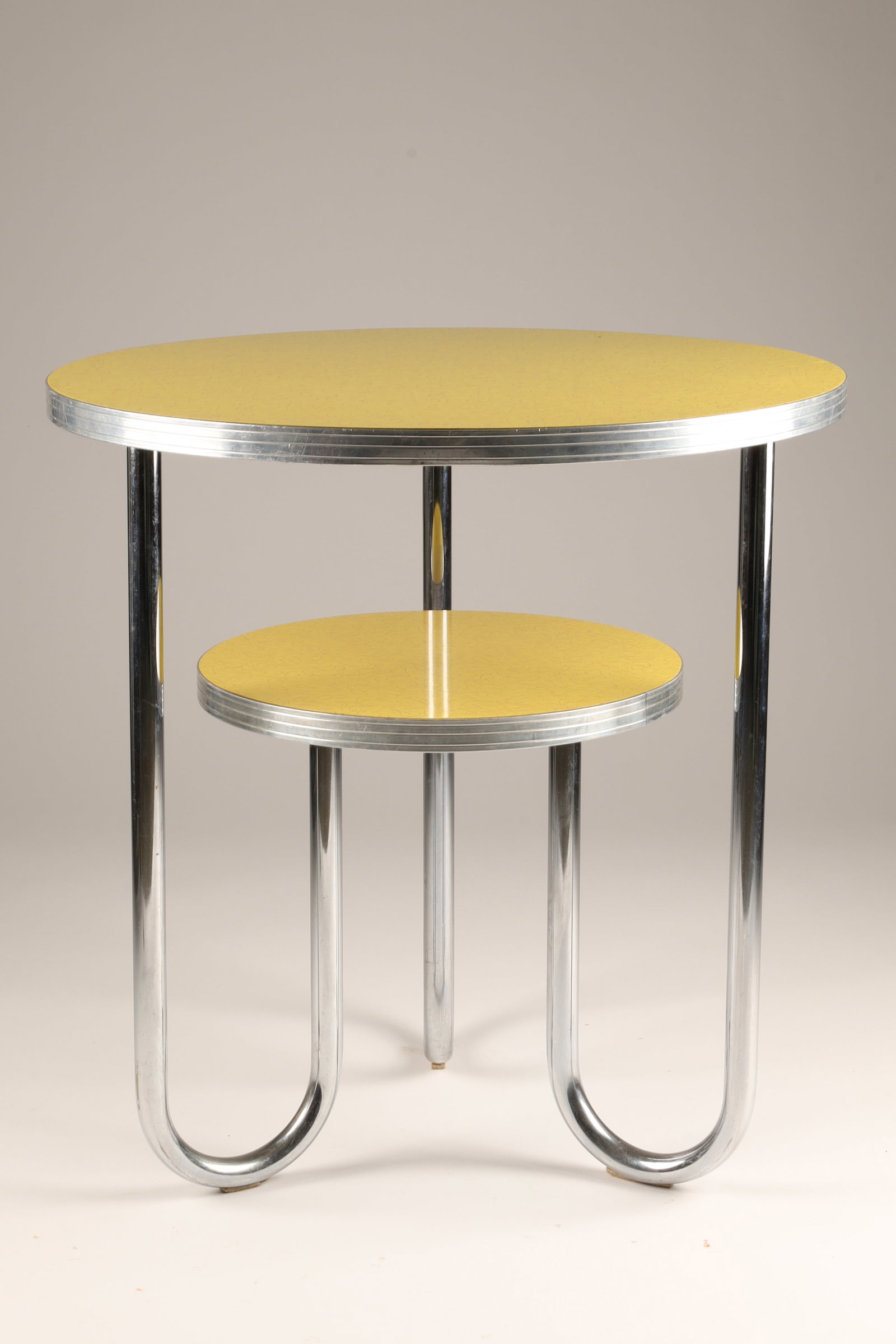 1930s Art Deco Royal Metal Manufacturing Two Tier Table by Wolfgang Hoffmann: A vintage 1930s Art Deco or Bauhaus-style two-tiered side table designed by Wolfgang Hoffmann manufactured by the Royal Metal Manufacturing Co, featuring tubular chrome U-shaped legs and yellow circul